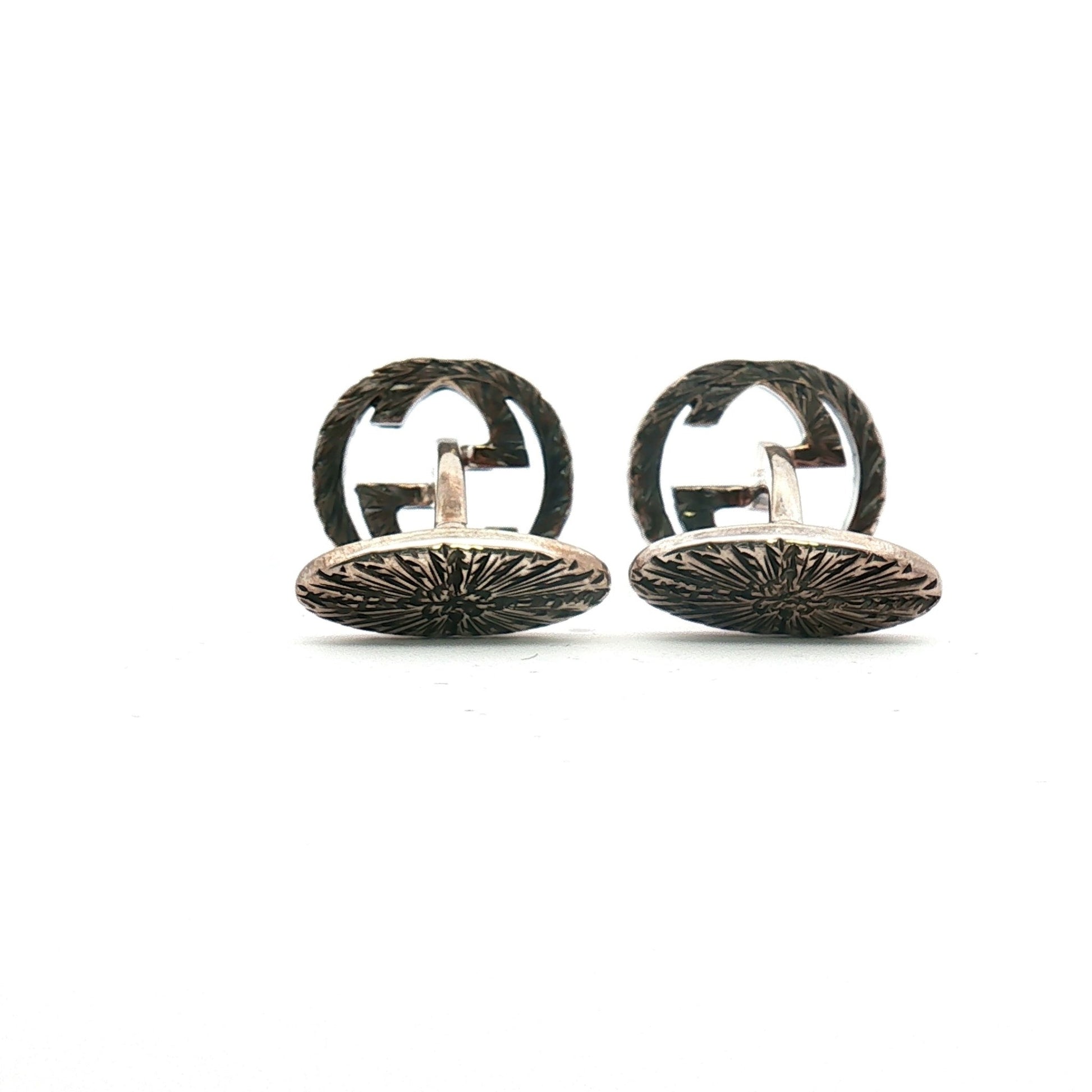 Sterling silver Gucci Interlocking G cufflinks, jewelry accessory with polished finish and detailed design, on a neutral background.