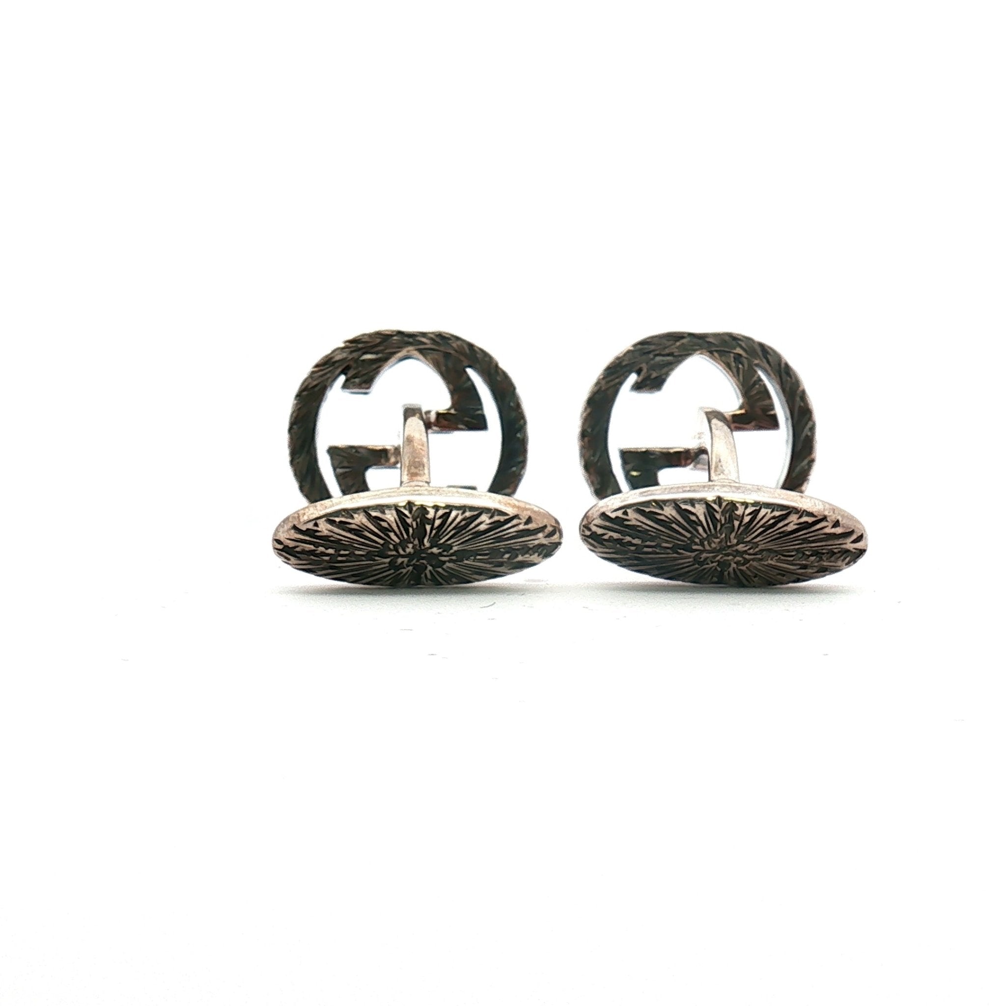 Sterling silver Gucci Interlocking G cufflinks, jewelry accessory with polished finish and detailed design, on a neutral background.
