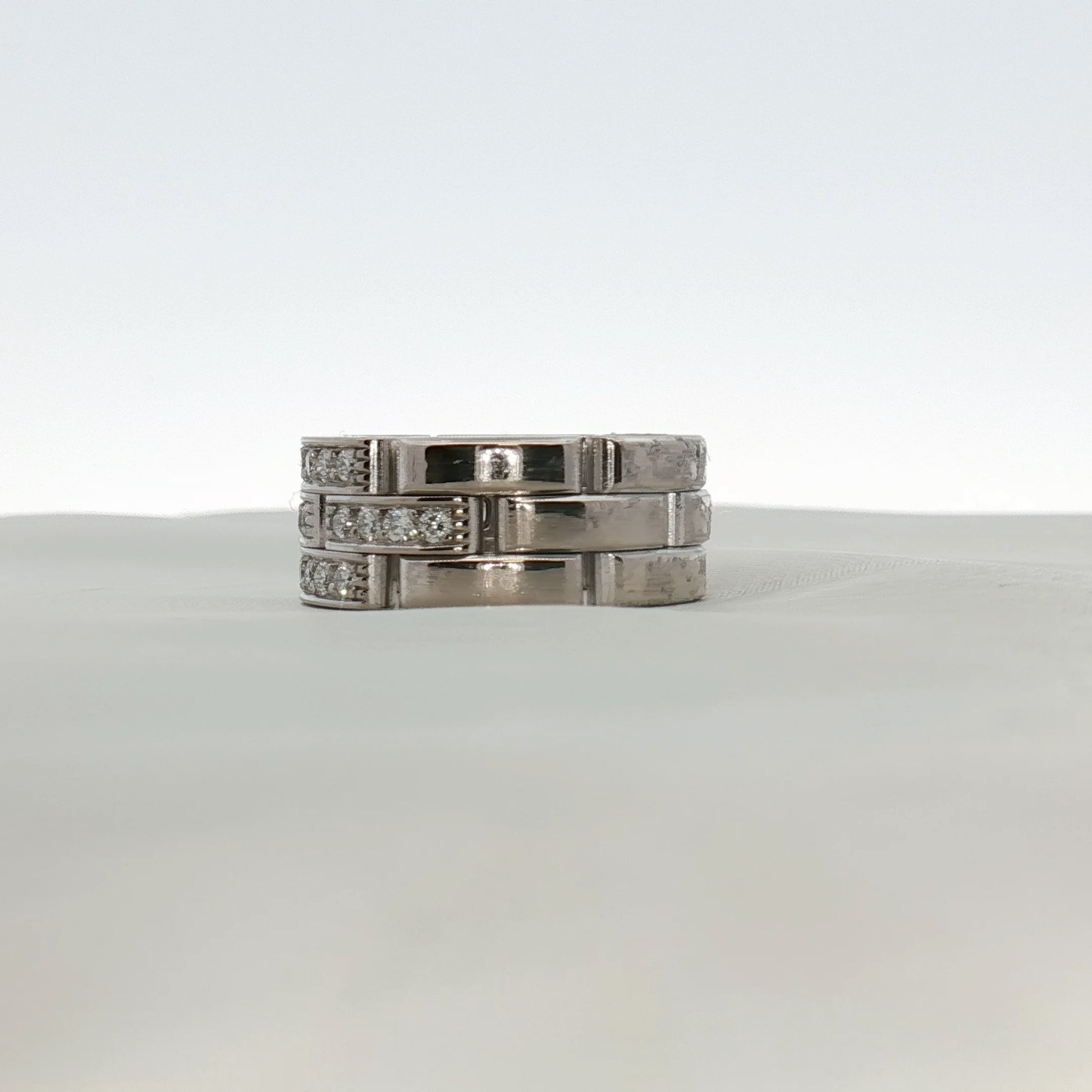 Cartier Maillon Diamond Ring featuring gold band and sparkling diamonds, elegant jewelry piece displayed on a white background.