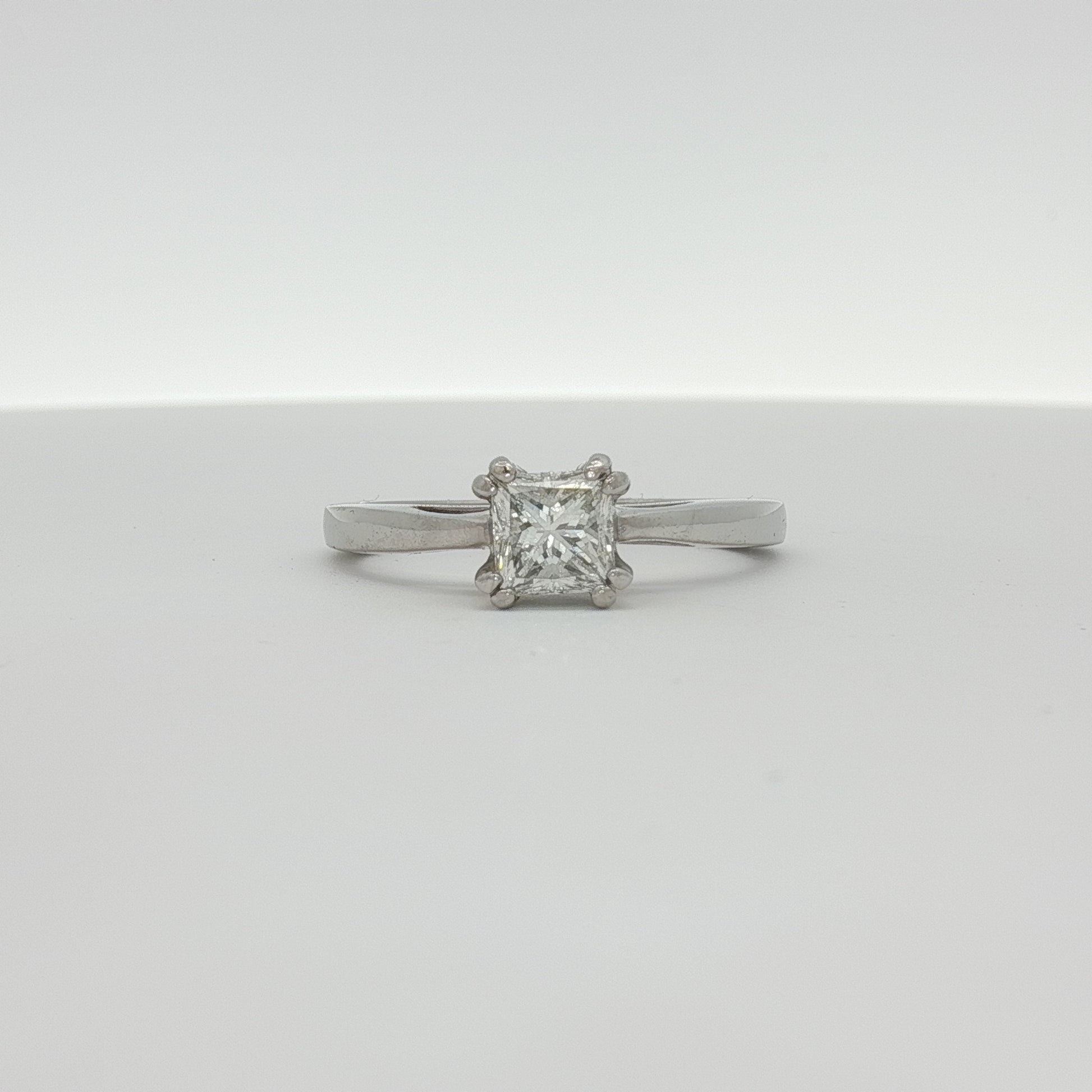 Platinum diamond solitaire engagement ring by Gold & Beyond with a sparkling central diamond and sleek band design.