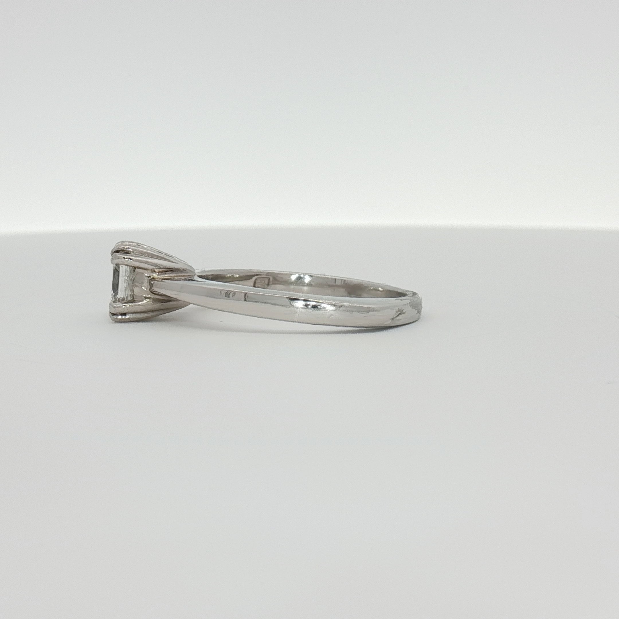 Platinum diamond solitaire engagement ring featuring a central sparkling diamond set on a sleek band.
