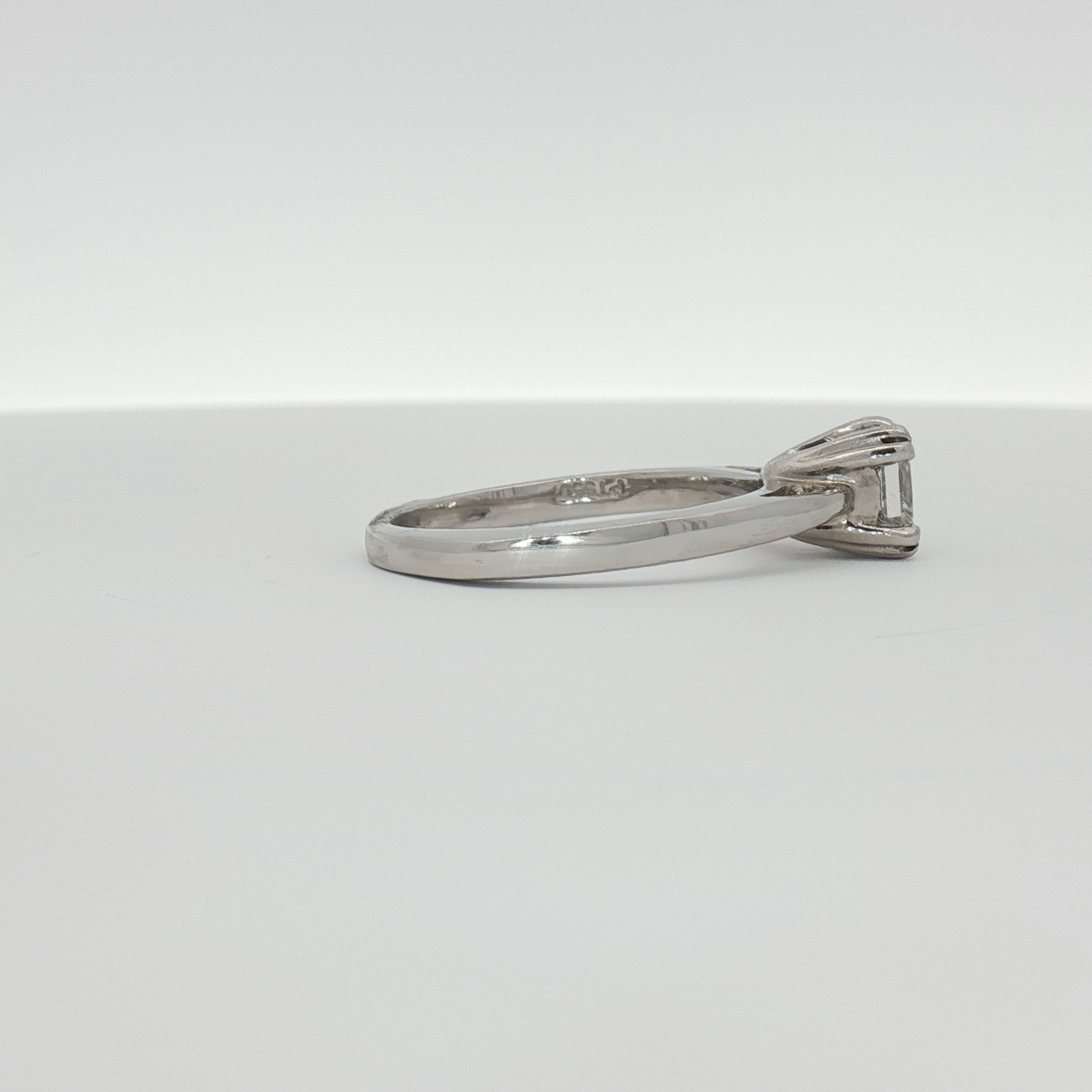 Platinum diamond solitaire engagement ring with a central sparkling diamond set on a sleek platinum band.