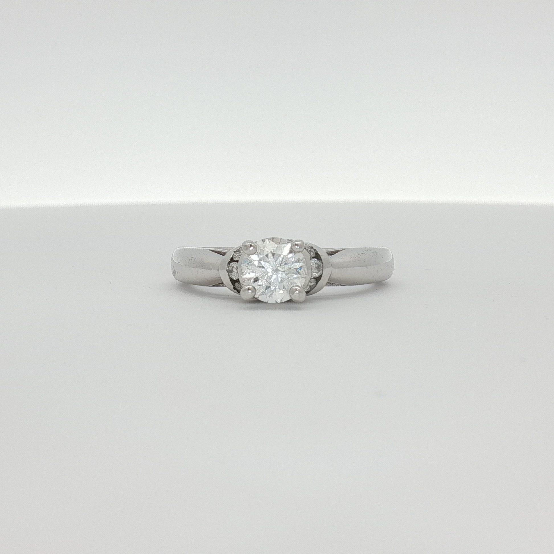 14K white gold diamond solitaire engagement ring featuring a central sparkling diamond and elegant band design.