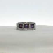 Three-stone diamond and purple gemstone ring by Gold & Beyond, showcasing sparkling diamonds and vibrant purple stones in elegant jewelry.