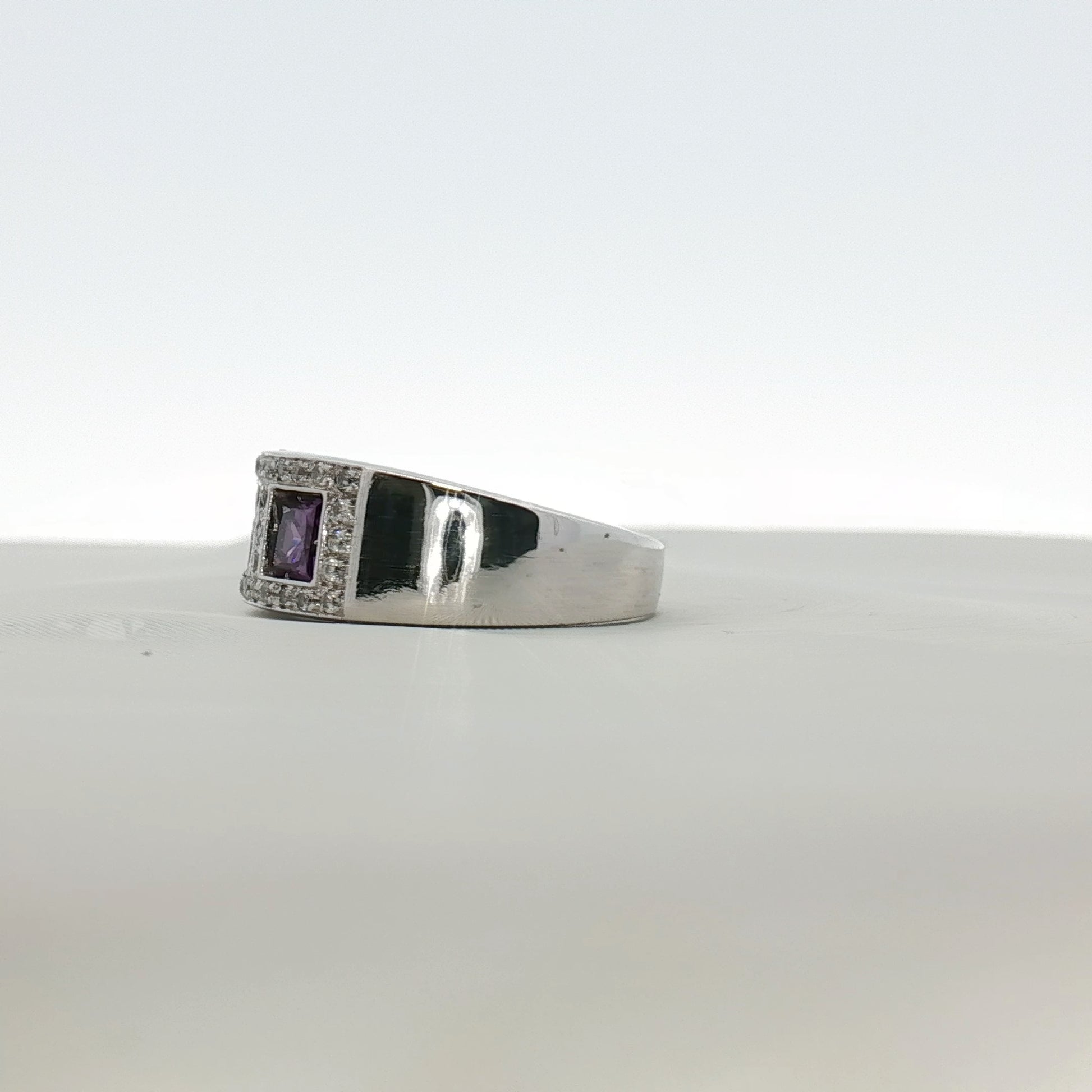 Three-stone diamond and purple gemstone ring by Gold & Beyond, showcasing sparkling diamonds and vibrant purple stones in elegant jewelry.