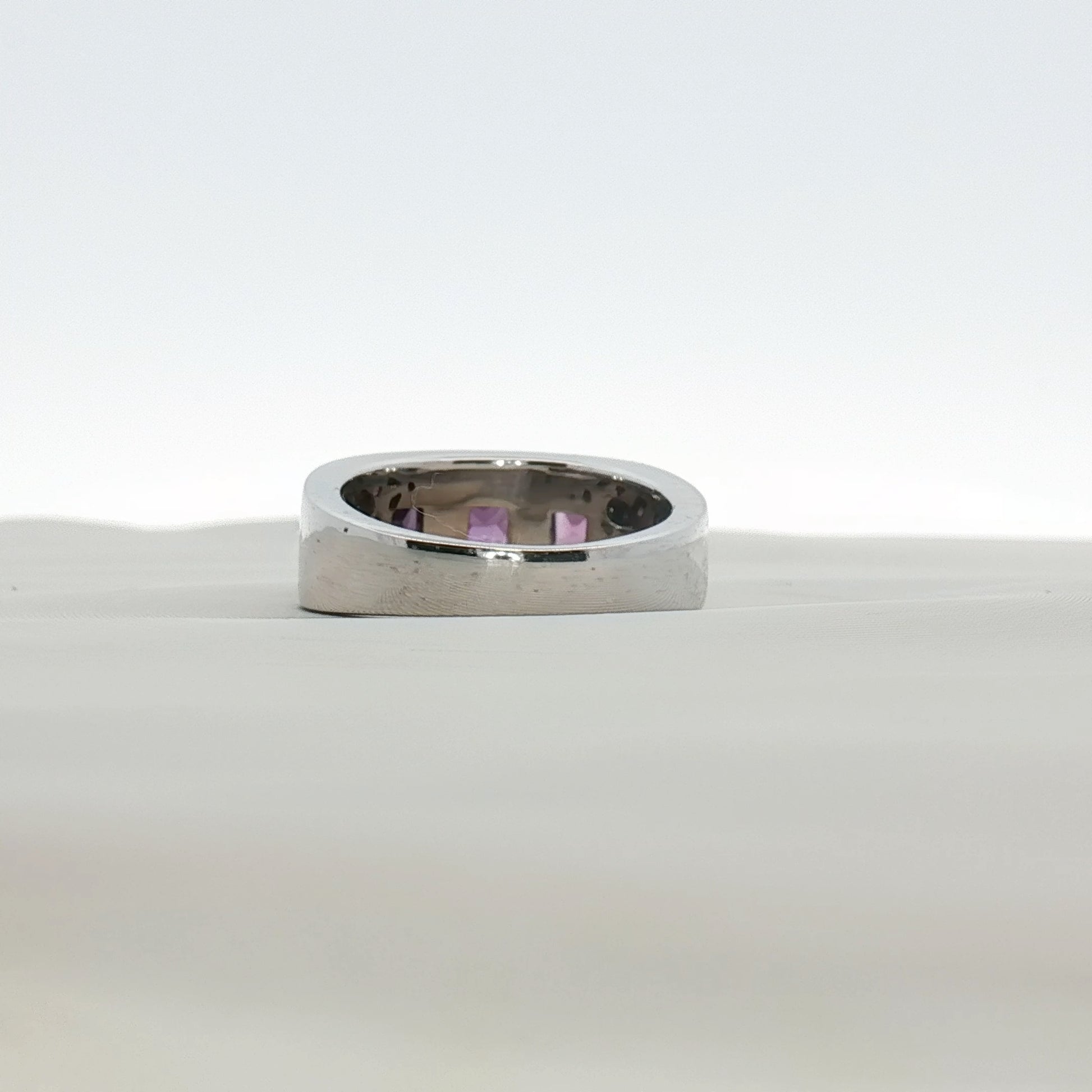Three-stone diamond and purple gemstone gold ring from Gold & Beyond, showcasing sparkling stones and elegant jewelry design.