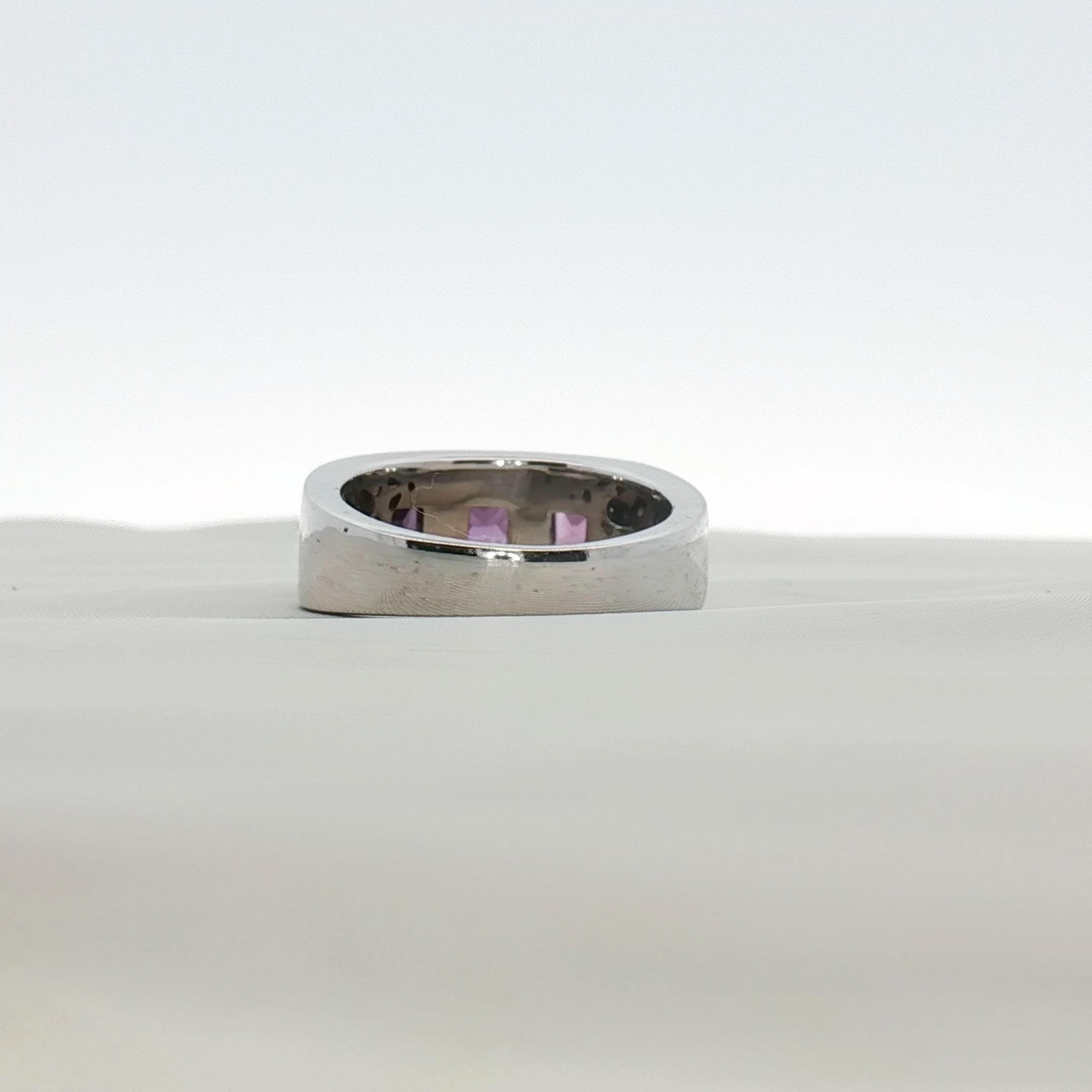 Three-stone diamond and purple gemstone gold ring from Gold & Beyond, showcasing sparkling stones and elegant jewelry design.