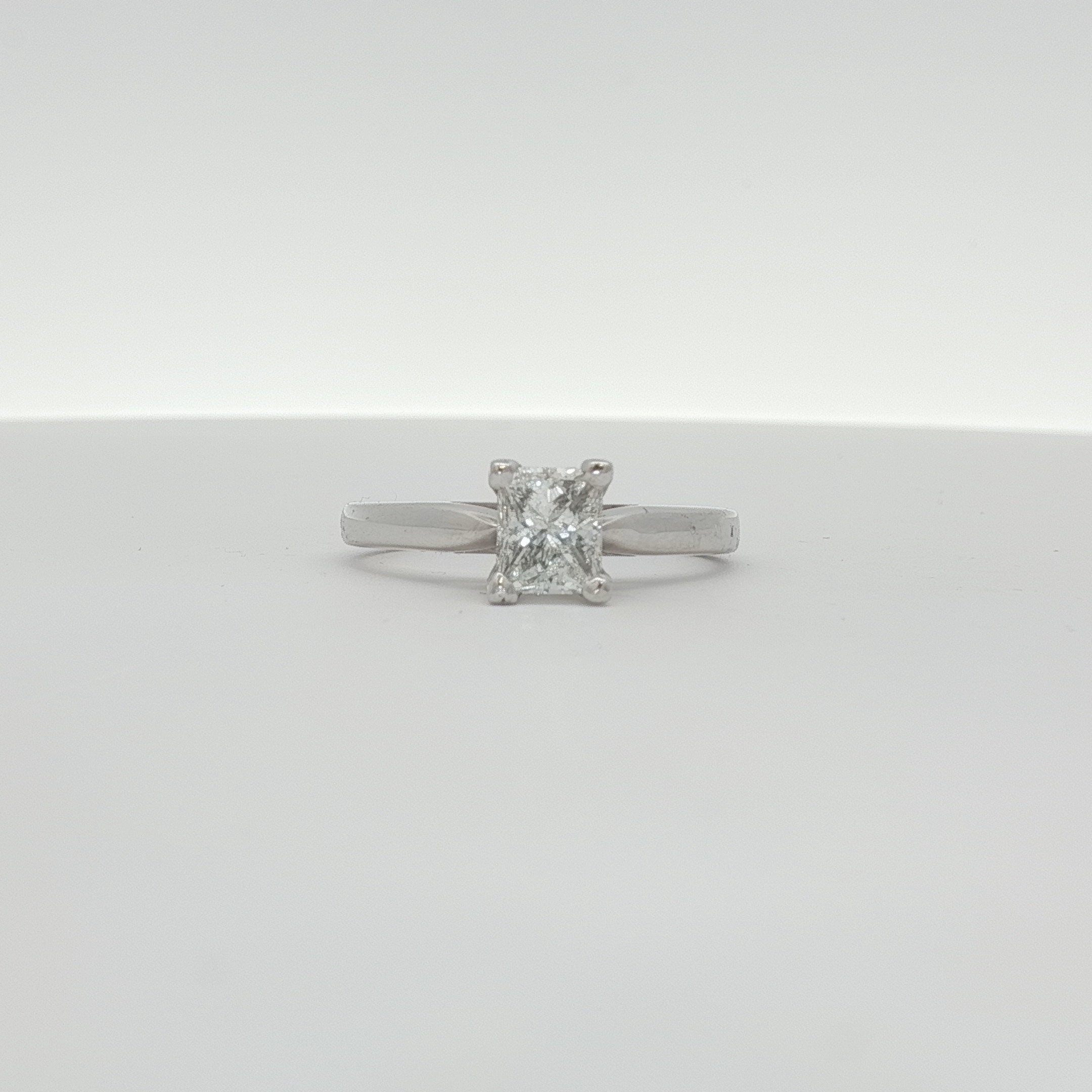 14K white gold diamond solitaire engagement ring with a sparkling center stone, showcased in a jewelry image.