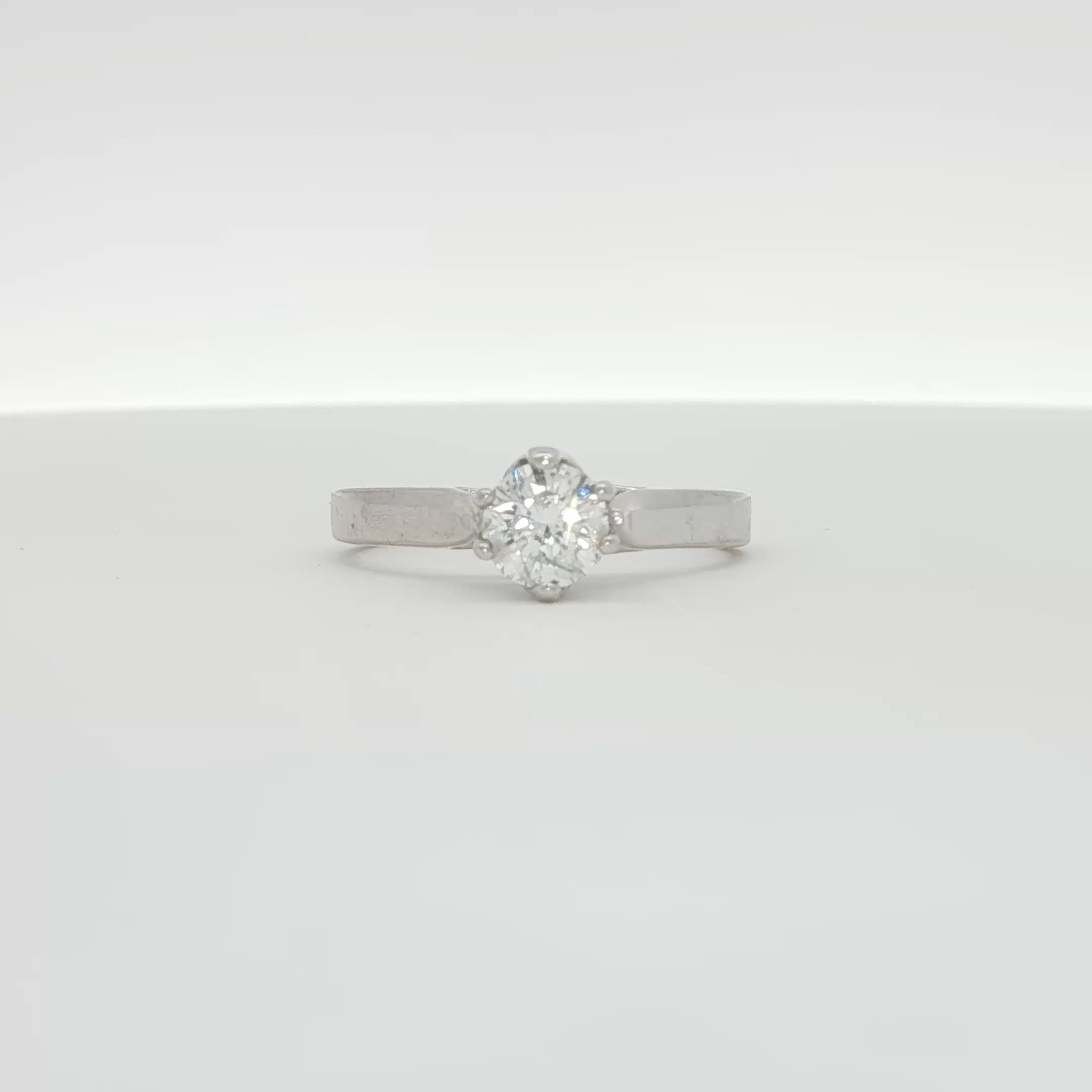 Elegant 10K white gold diamond solitaire ring with a central sparkling diamond, showcasing fine jewelry craftsmanship.