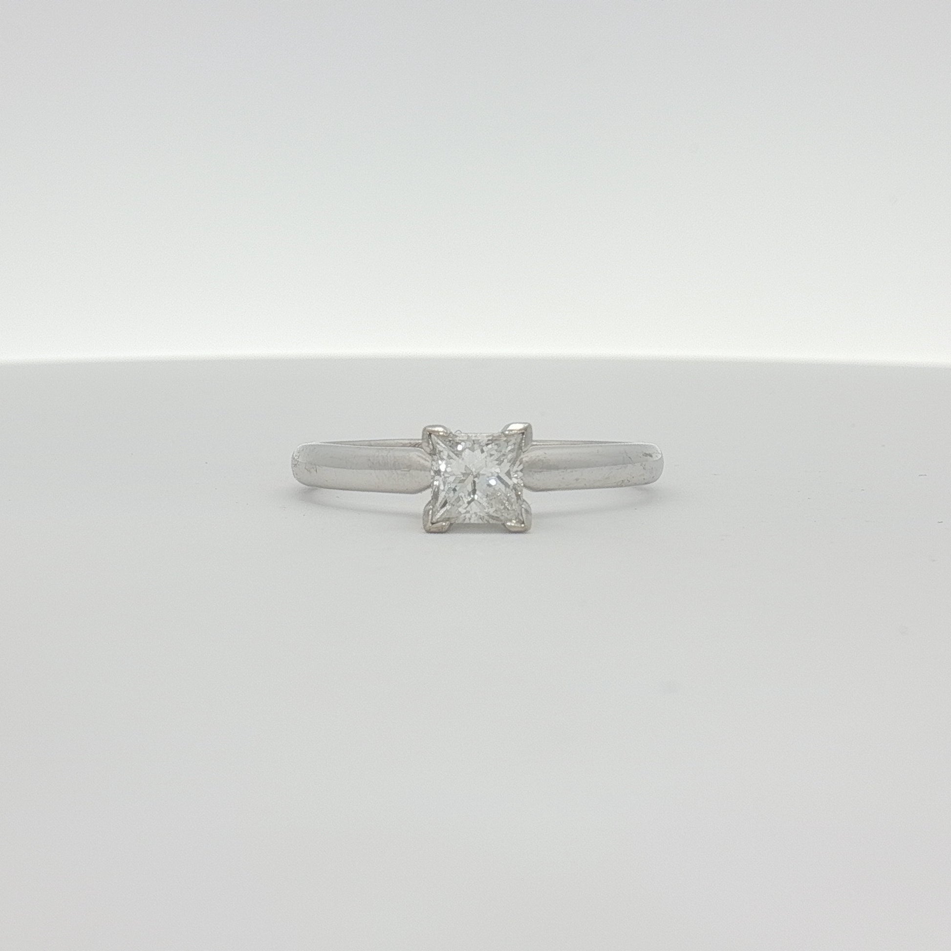 14K white gold diamond solitaire engagement ring featuring a central sparkling diamond and a sleek, elegant band.