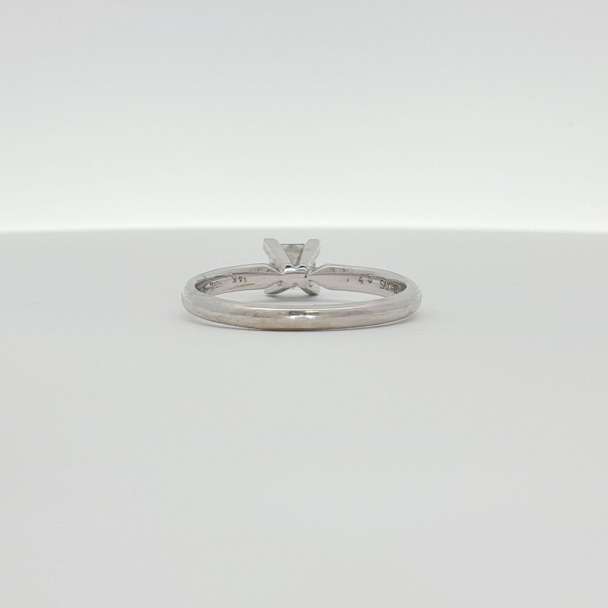 14K white gold diamond solitaire engagement ring with a round brilliant cut diamond, featuring a sleek and elegant jewelry design.
