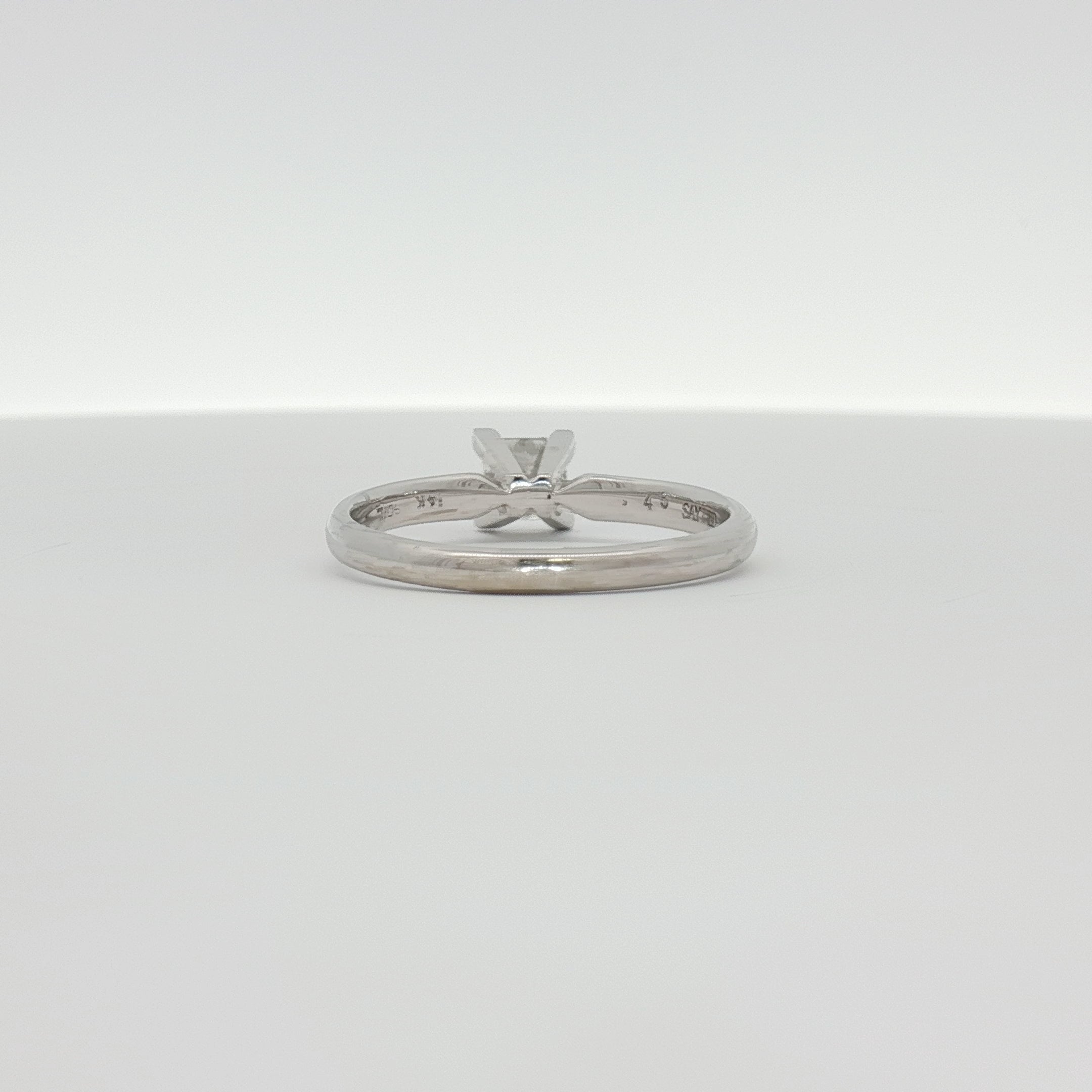 14K white gold diamond solitaire engagement ring with a round brilliant cut diamond, featuring a sleek and elegant jewelry design.