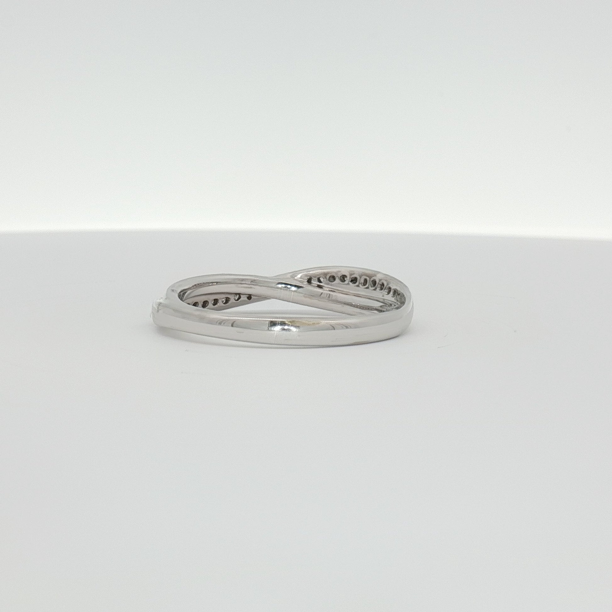 White gold diamond twist band ring with sparkling diamonds, crafted by Gold & Beyond, elegant jewelry piece.