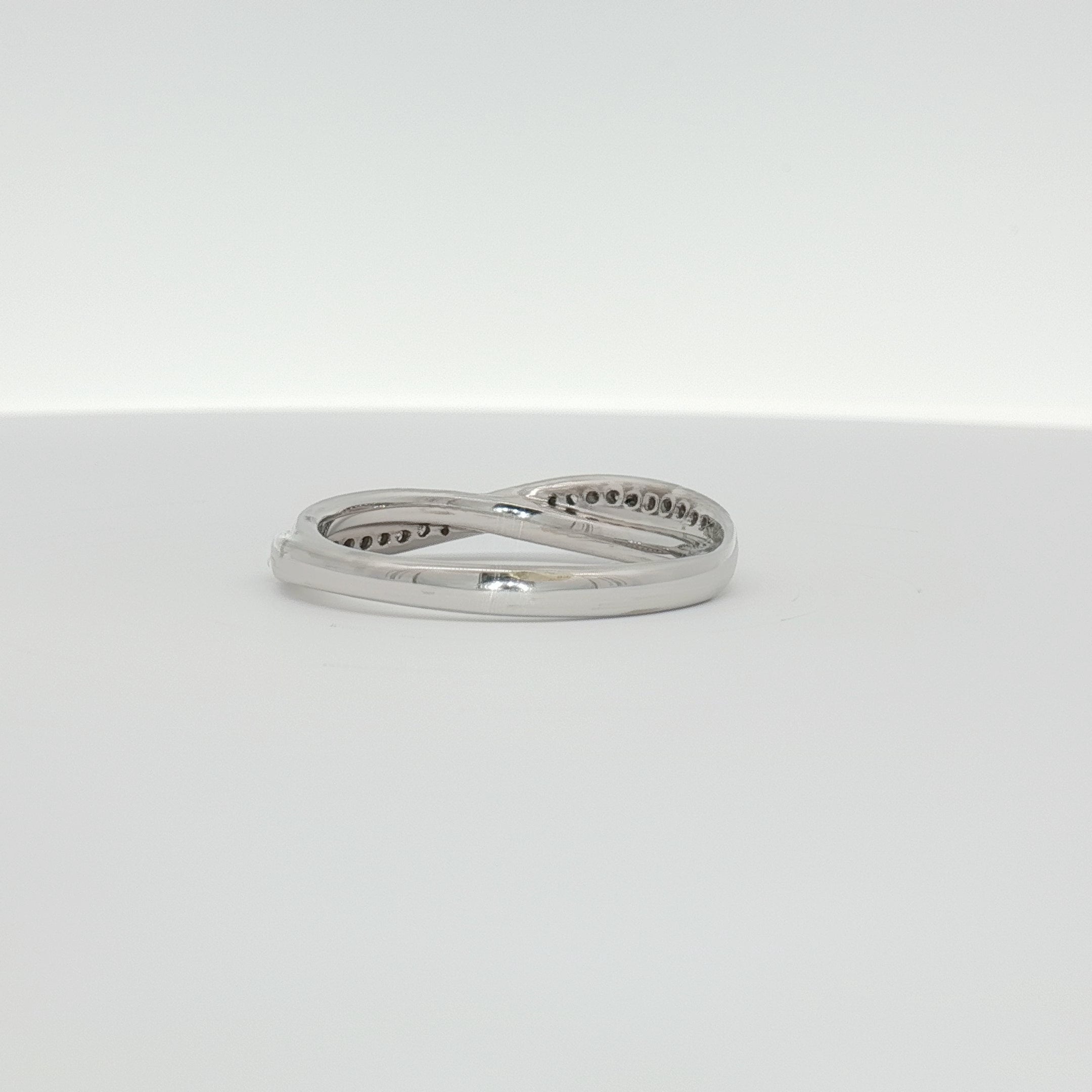 White gold diamond twist band ring with sparkling diamonds, crafted by Gold & Beyond, elegant jewelry piece.