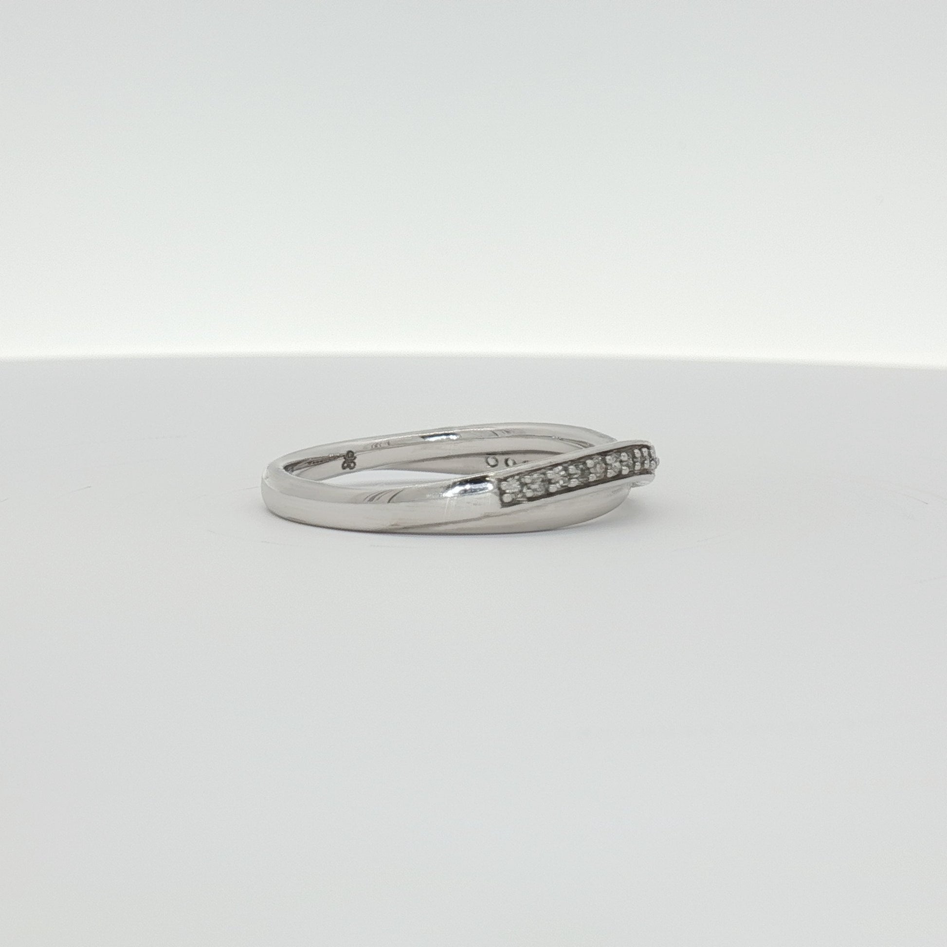 Elegant 10K white gold diamond twist band ring showcasing sparkling diamonds and intricate design from Gold & Beyond jewelry collection.