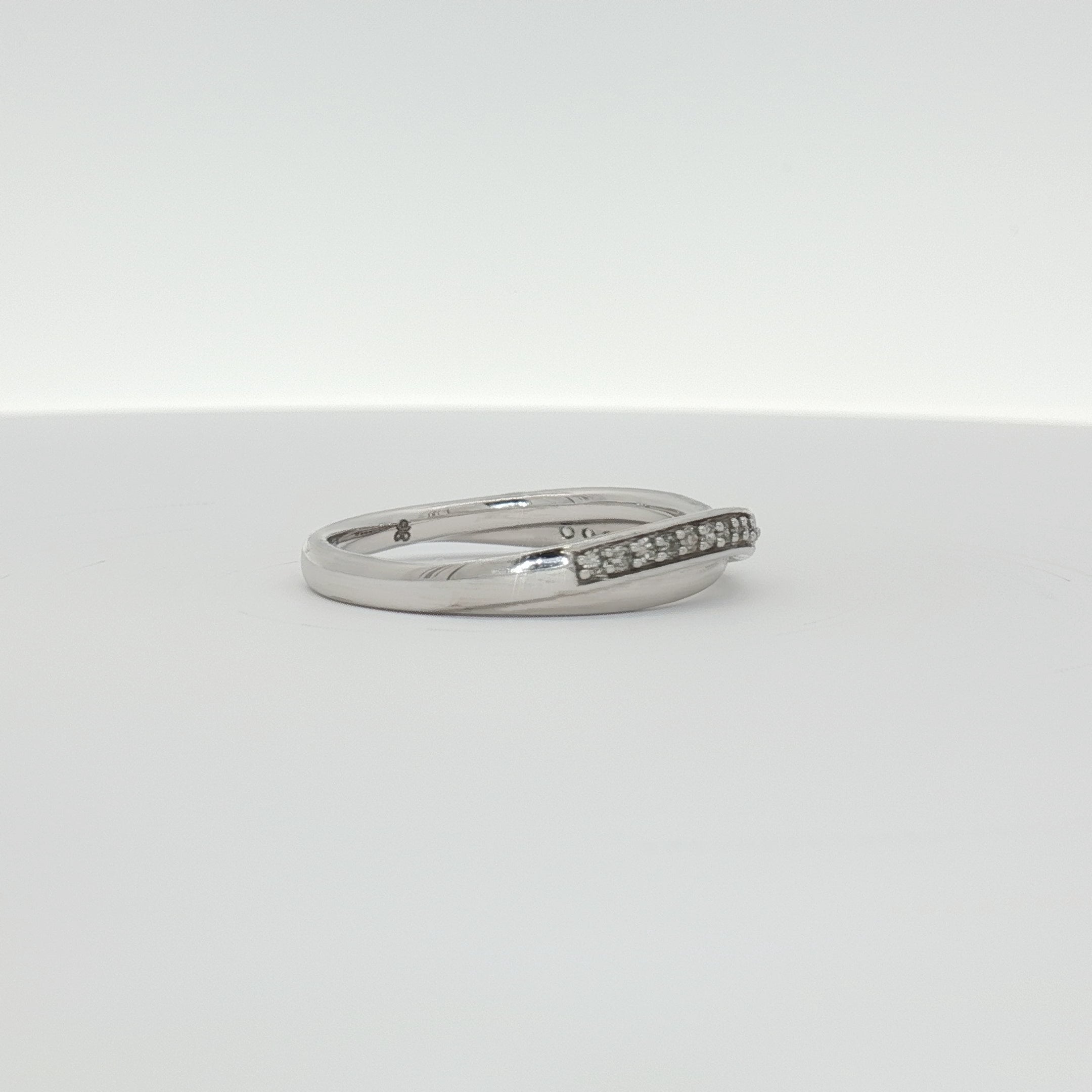 Elegant 10K white gold diamond twist band ring showcasing sparkling diamonds and intricate design from Gold & Beyond jewelry collection.