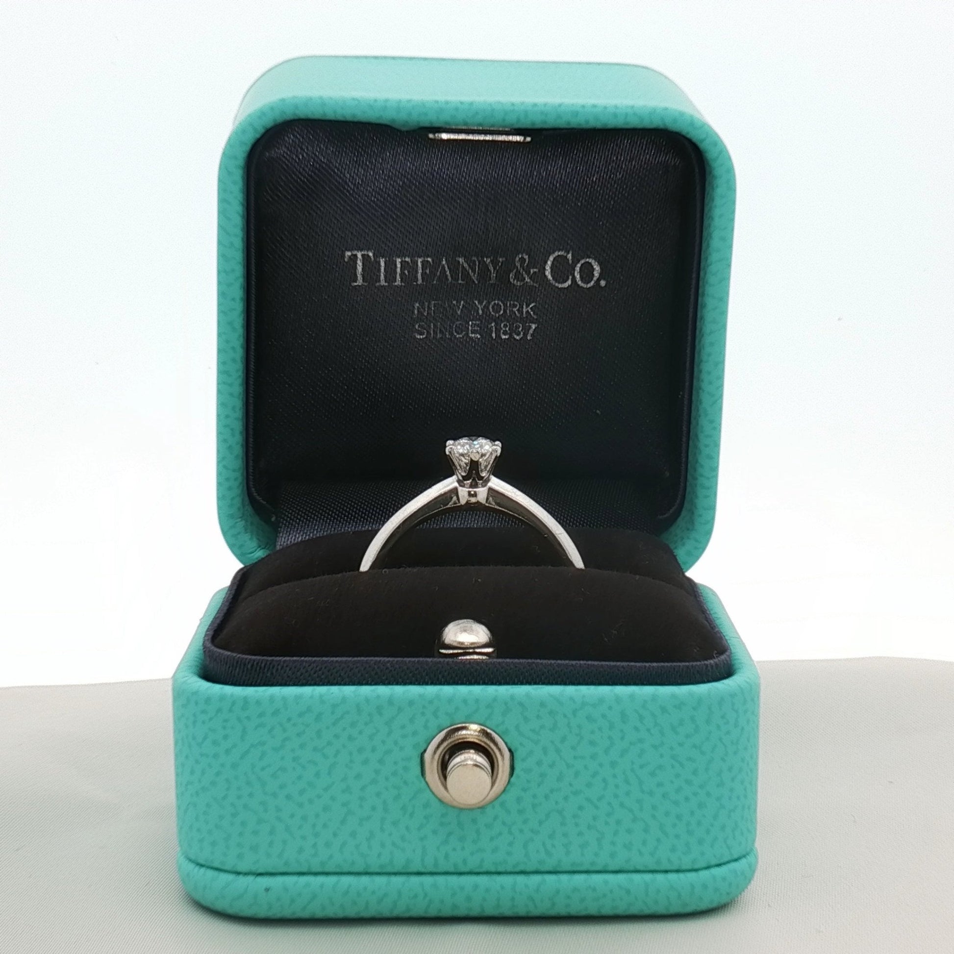 Tiffany & Co. platinum diamond solitaire ring, showcasing a single sparkling diamond set on a sleek platinum band.