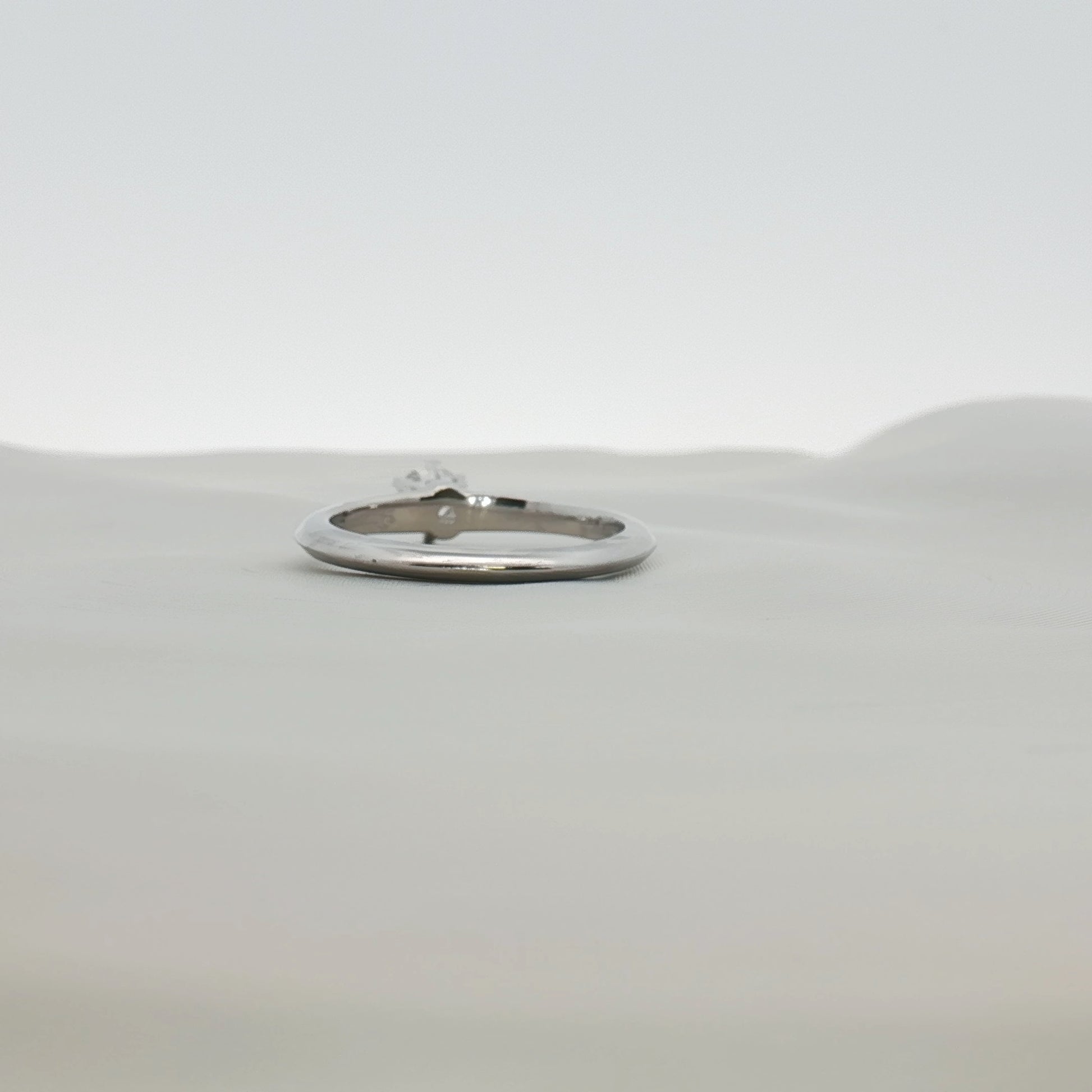 Tiffany & Co. platinum diamond solitaire ring with a single sparkling diamond set on a sleek band.