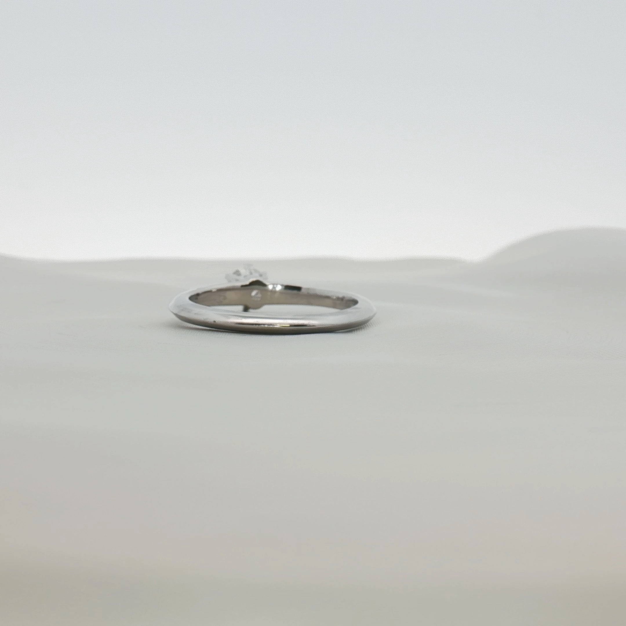 Tiffany & Co. platinum diamond solitaire ring with a single sparkling diamond set on a sleek band.