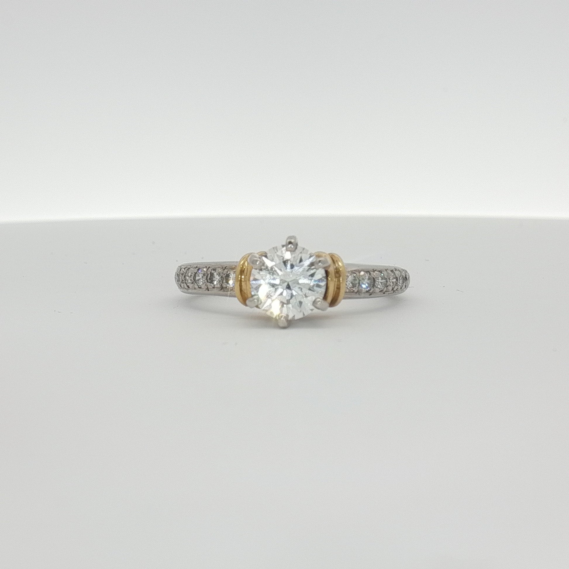 Platinum diamond engagement ring from Gold & Beyond featuring a central sparkling diamond set in elegant jewelry design.