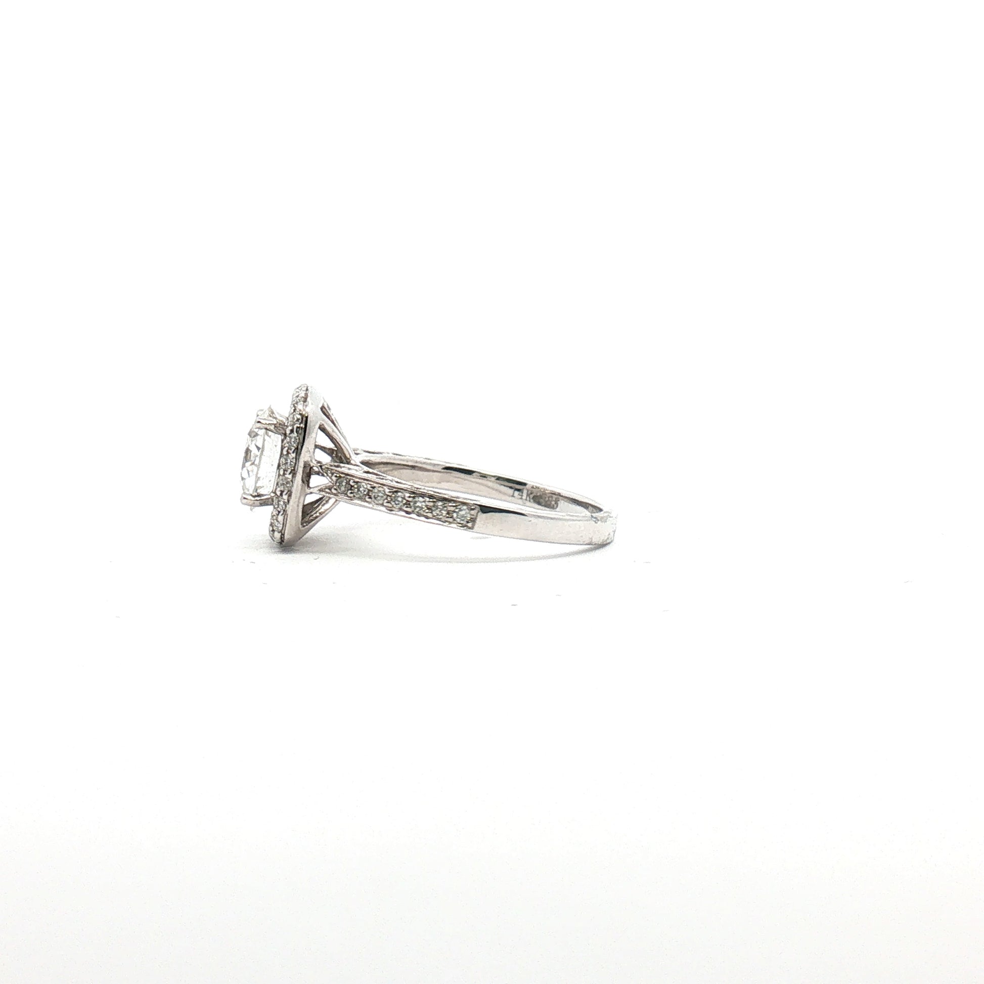 14K white gold diamond halo ring with a central gemstone and intricate detailing, showcasing elegant jewelry craftsmanship.