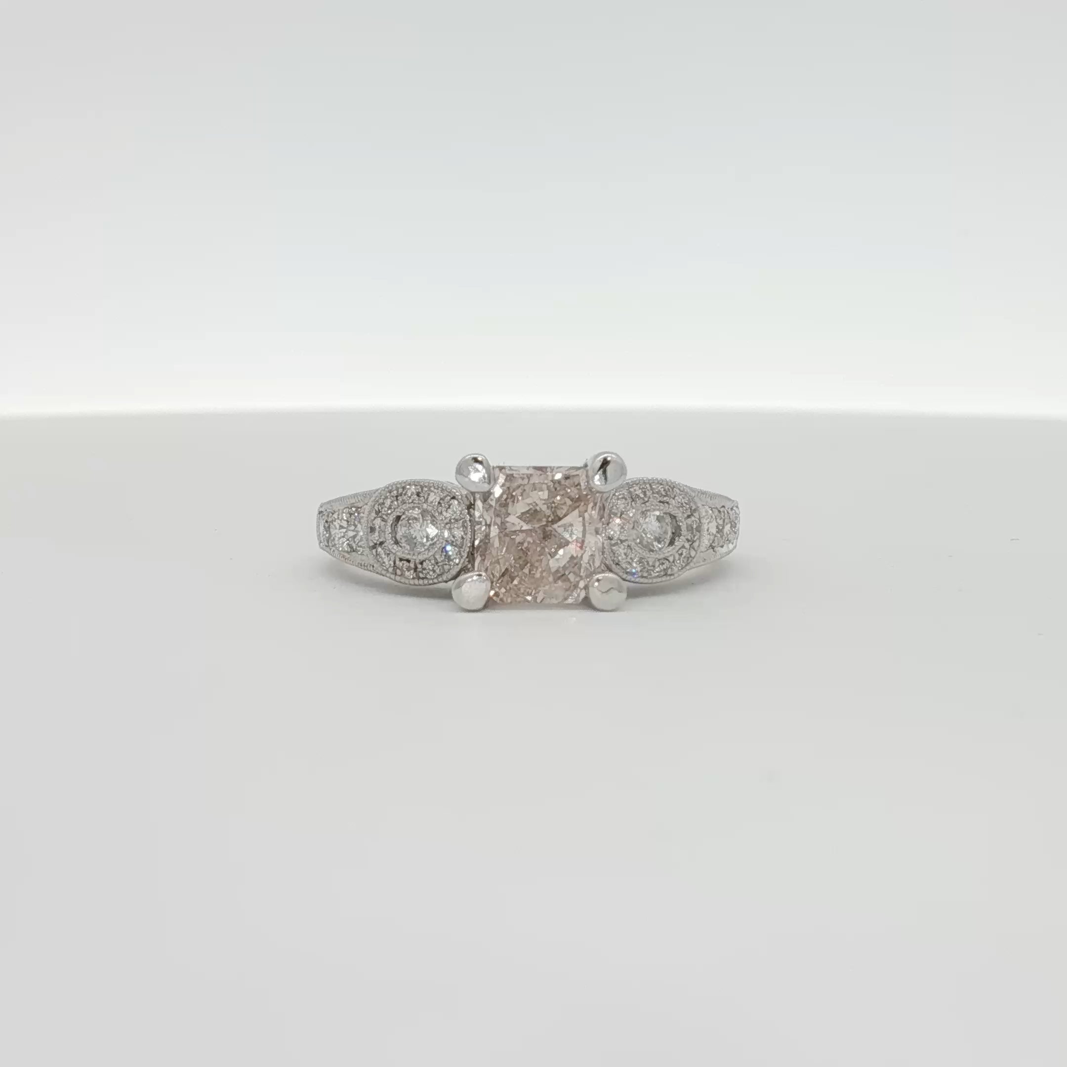 Elegant 18K white gold diamond ring by Gold & Beyond featuring a sparkling central diamond and intricate band design.