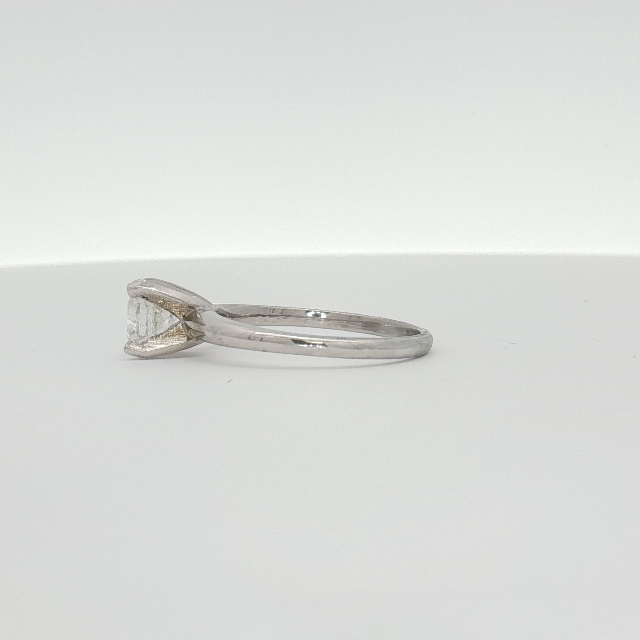 14K white gold diamond engagement ring with a central round diamond and side accent stones, crafted by Gold & Beyond.