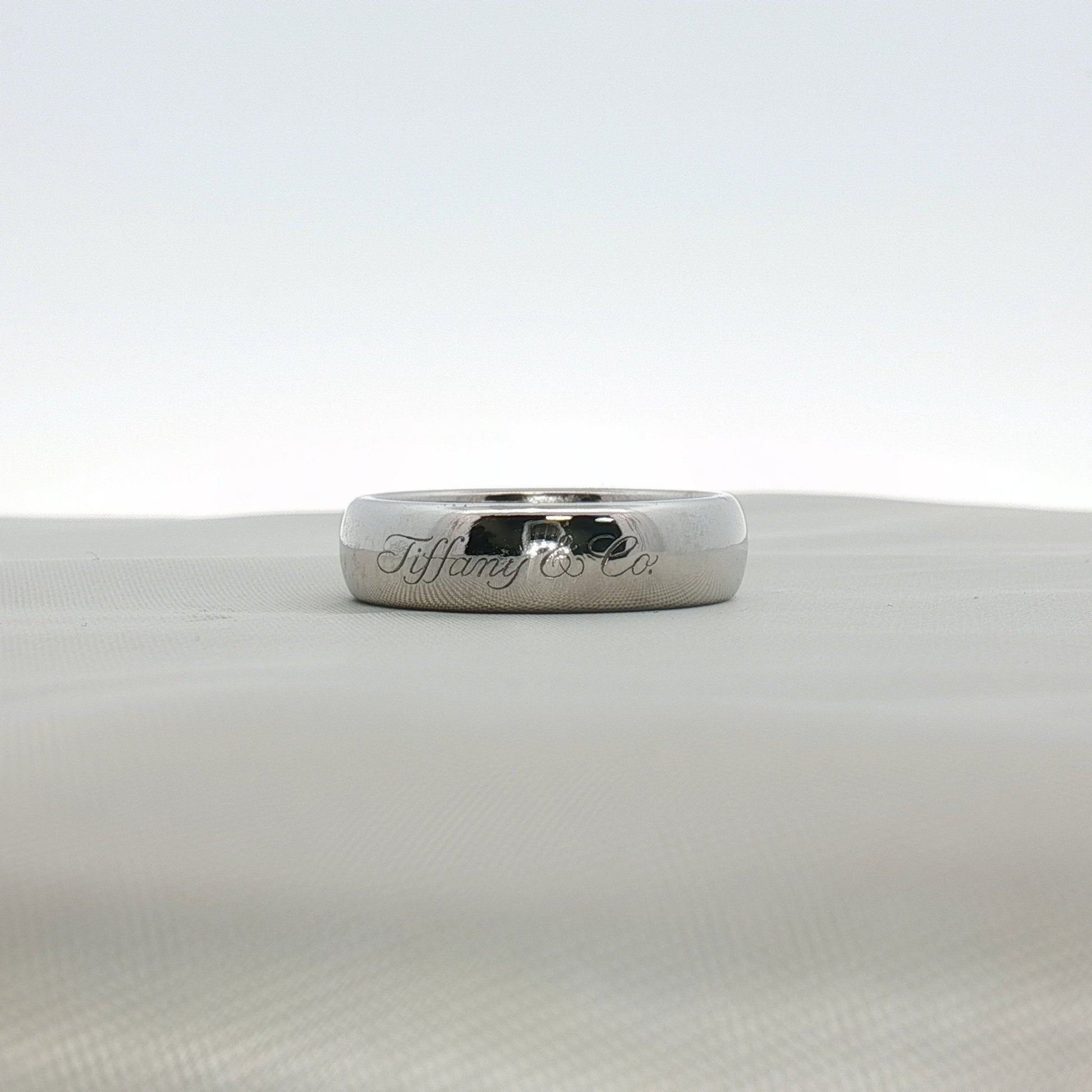 Platinum wedding band ring from Tiffany & Co. featuring a sleek, polished jewelry design with subtle branding details.
