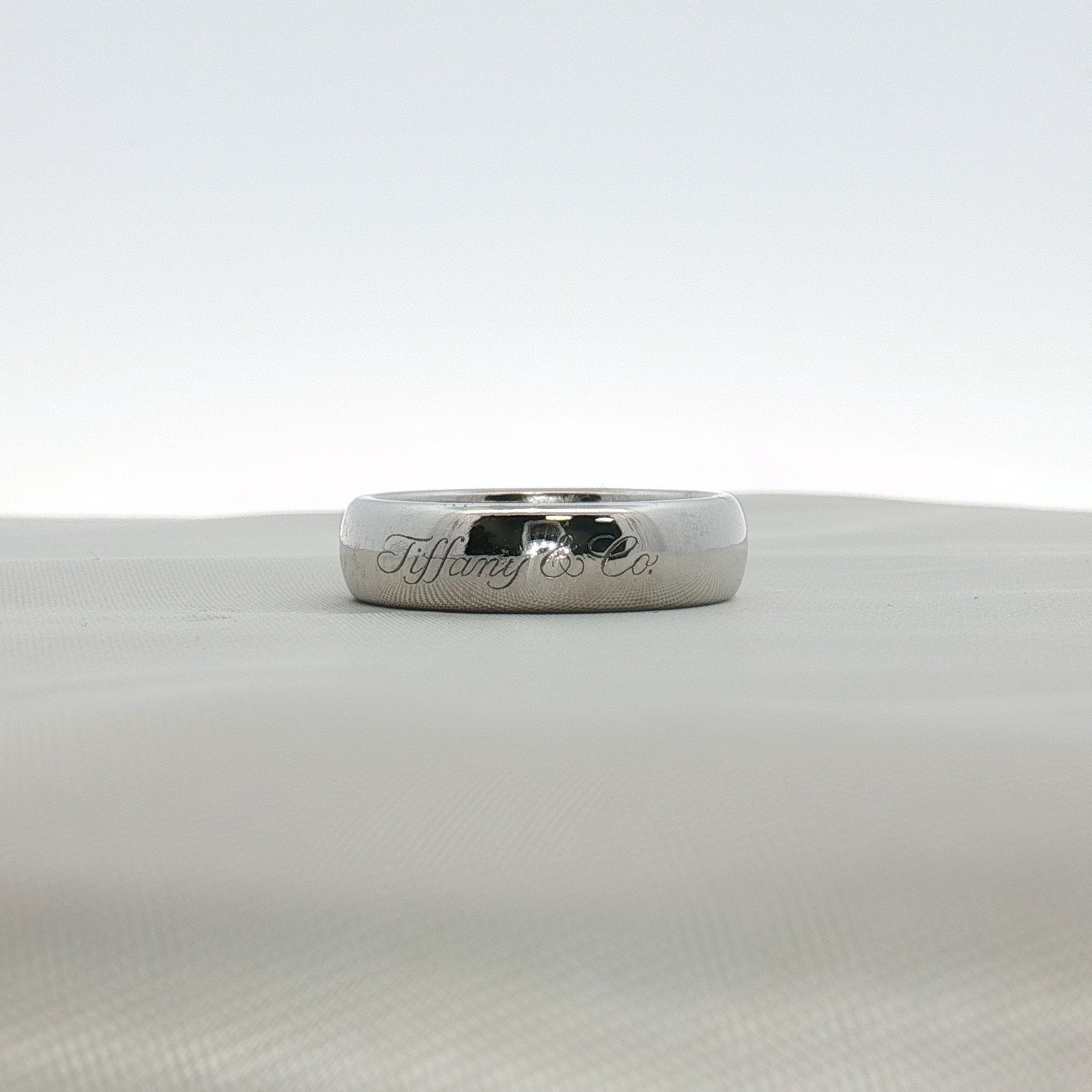 Platinum wedding band ring from Tiffany & Co., featuring a sleek, polished design, set in elegant jewelry style.
