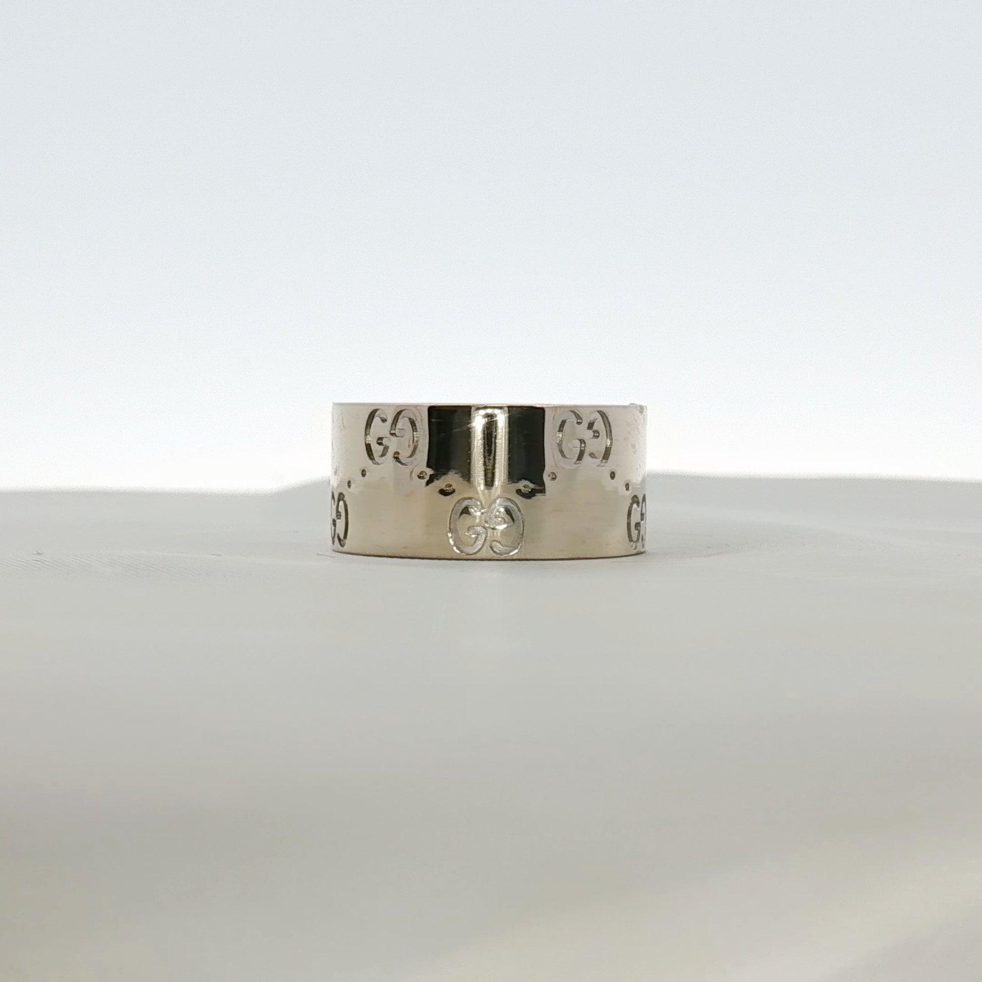 Gold & Beyond Gucci Interlocking G wide band jewelry ring with a bold, engraved interlocking G design on polished gold metal.