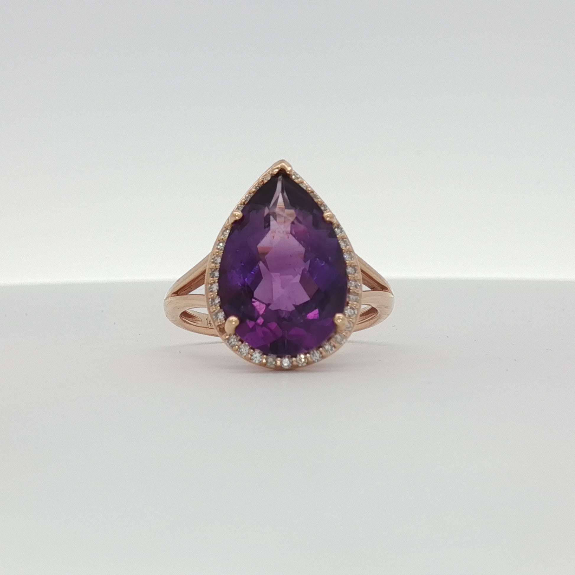 14K yellow gold amethyst and diamond halo ring with intricate gemstone setting, showcasing elegant jewelry craftsmanship.