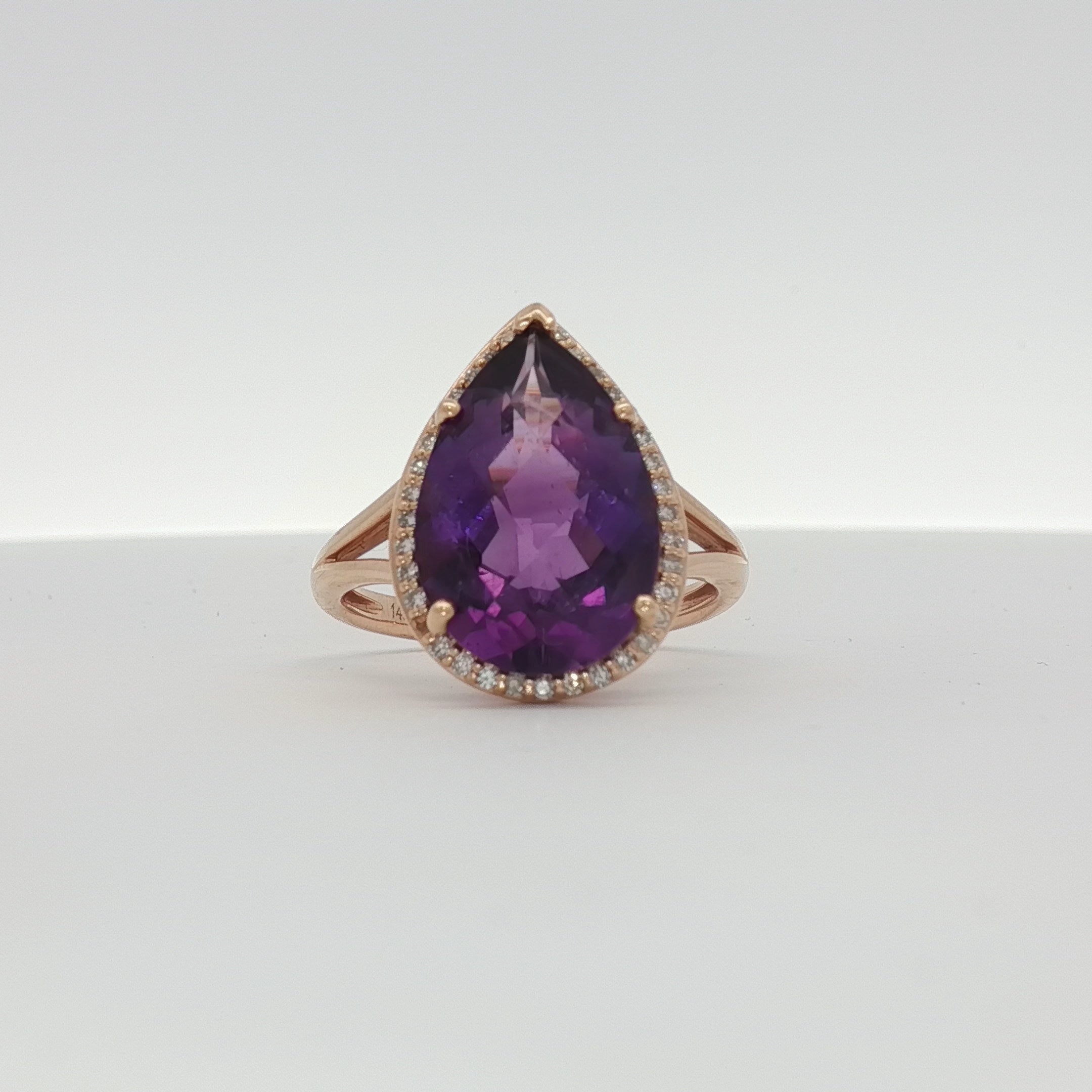 14K yellow gold amethyst and diamond halo ring with intricate gemstone setting, showcasing elegant jewelry craftsmanship.