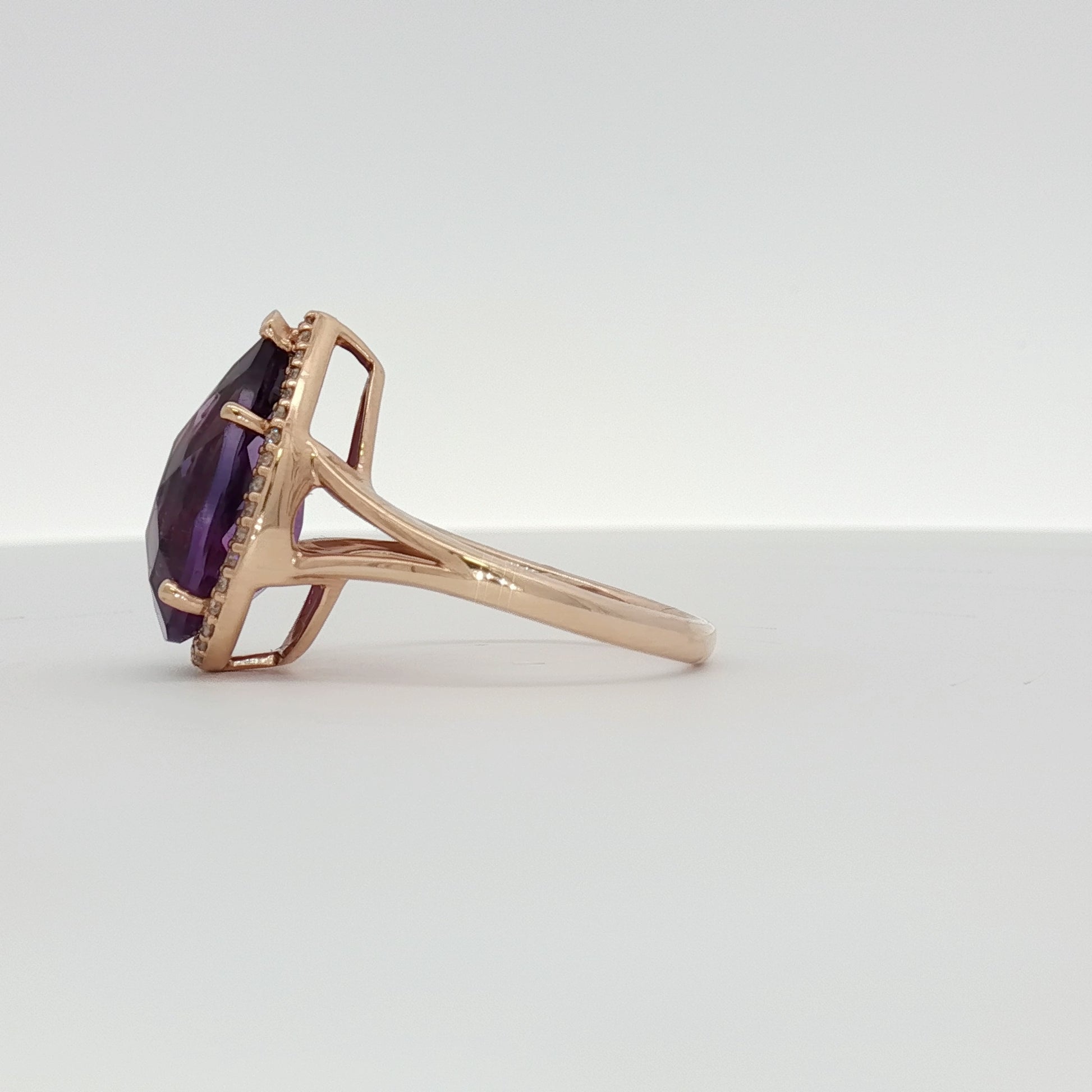 14K yellow gold amethyst and diamond halo ring featuring a central purple gemstone and sparkling accents, jewelry by Gold & Beyond