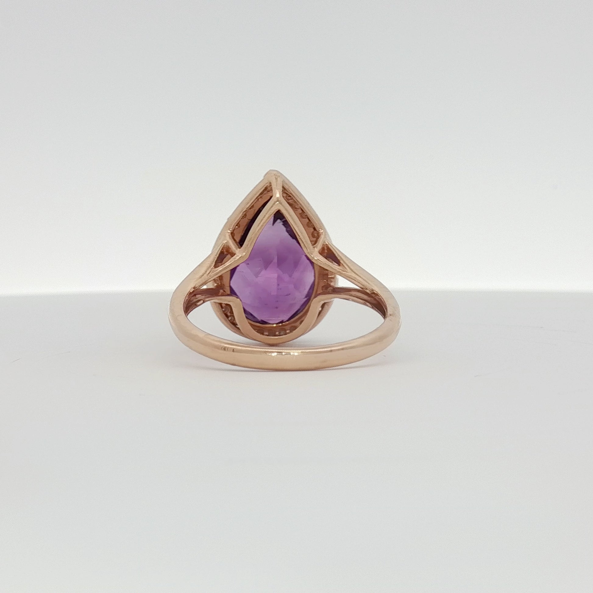 14K yellow gold amethyst and diamond halo ring with intricate design, showcasing vibrant purple gemstone and sparkling accents.