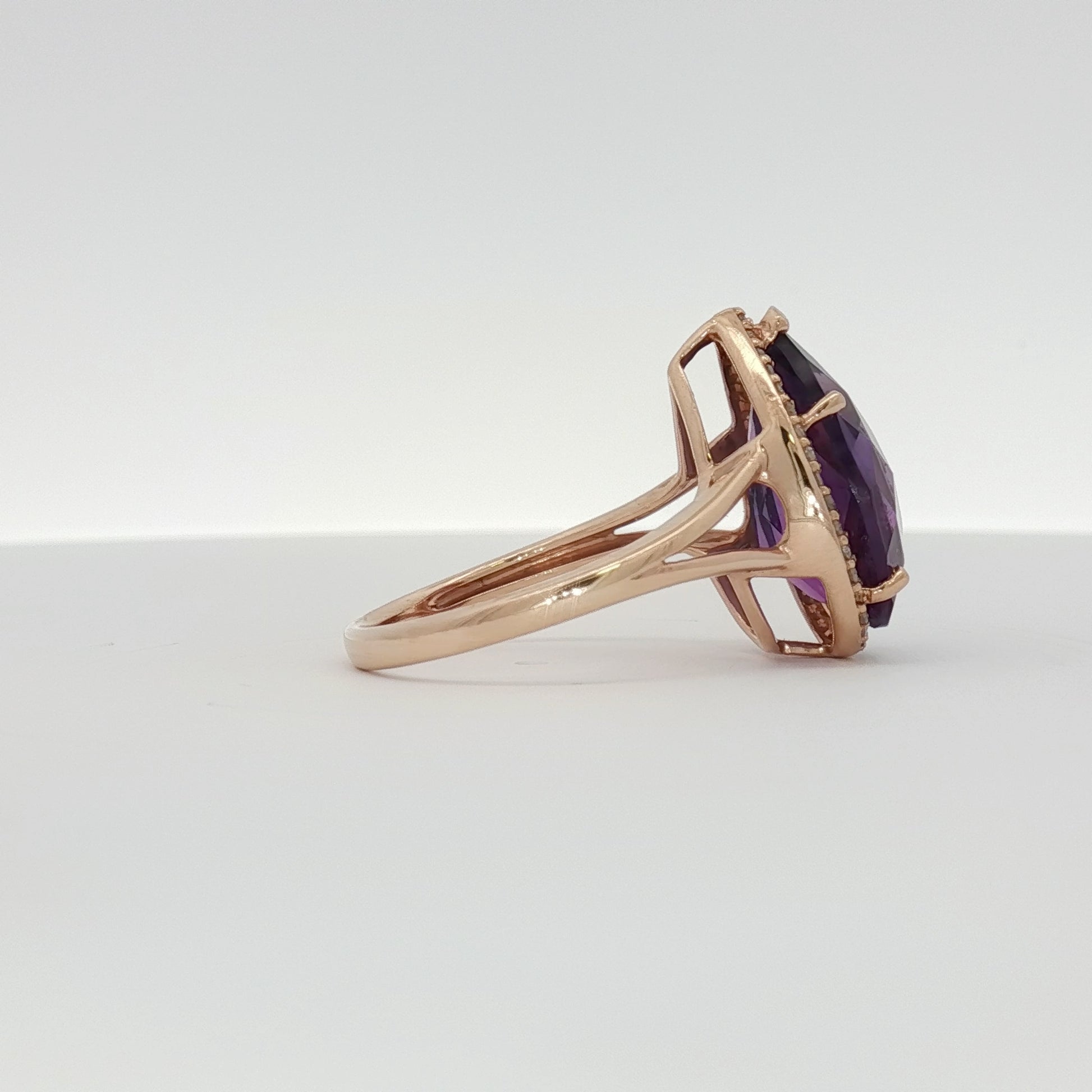 14K yellow gold amethyst and diamond halo ring featuring a central purple gemstone and sparkling accents, designed by Gold & Beyond.