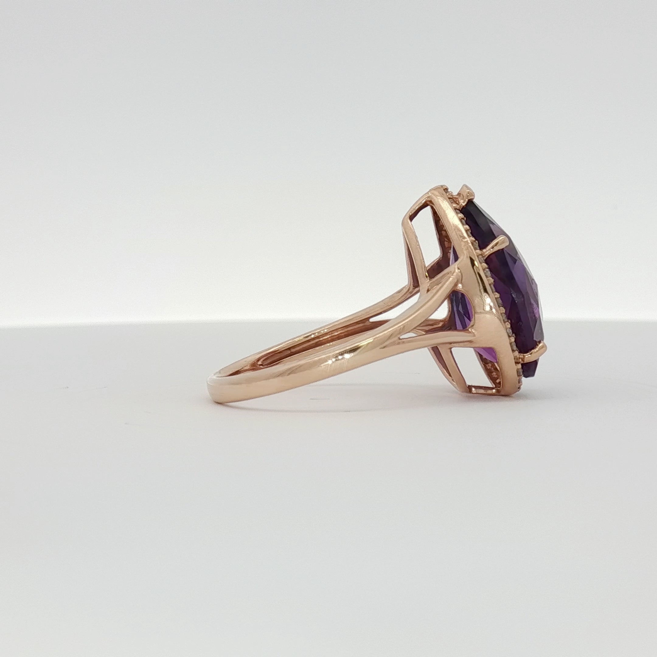 14K yellow gold amethyst and diamond halo ring featuring a central purple gemstone and sparkling accents, designed by Gold & Beyond.