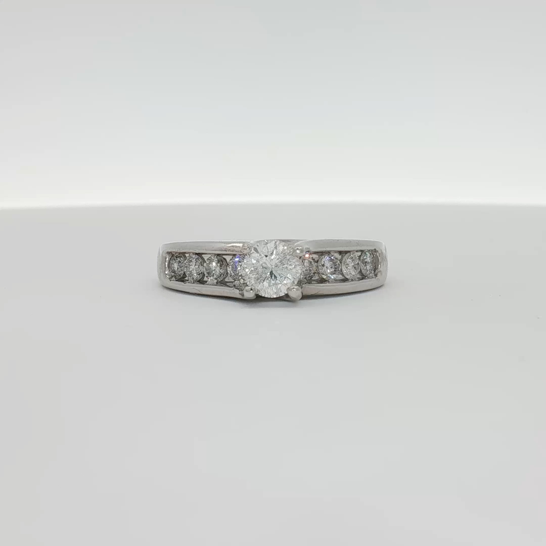 Platinum diamond ring by Gold & Beyond featuring a sparkling central diamond on a sleek band.