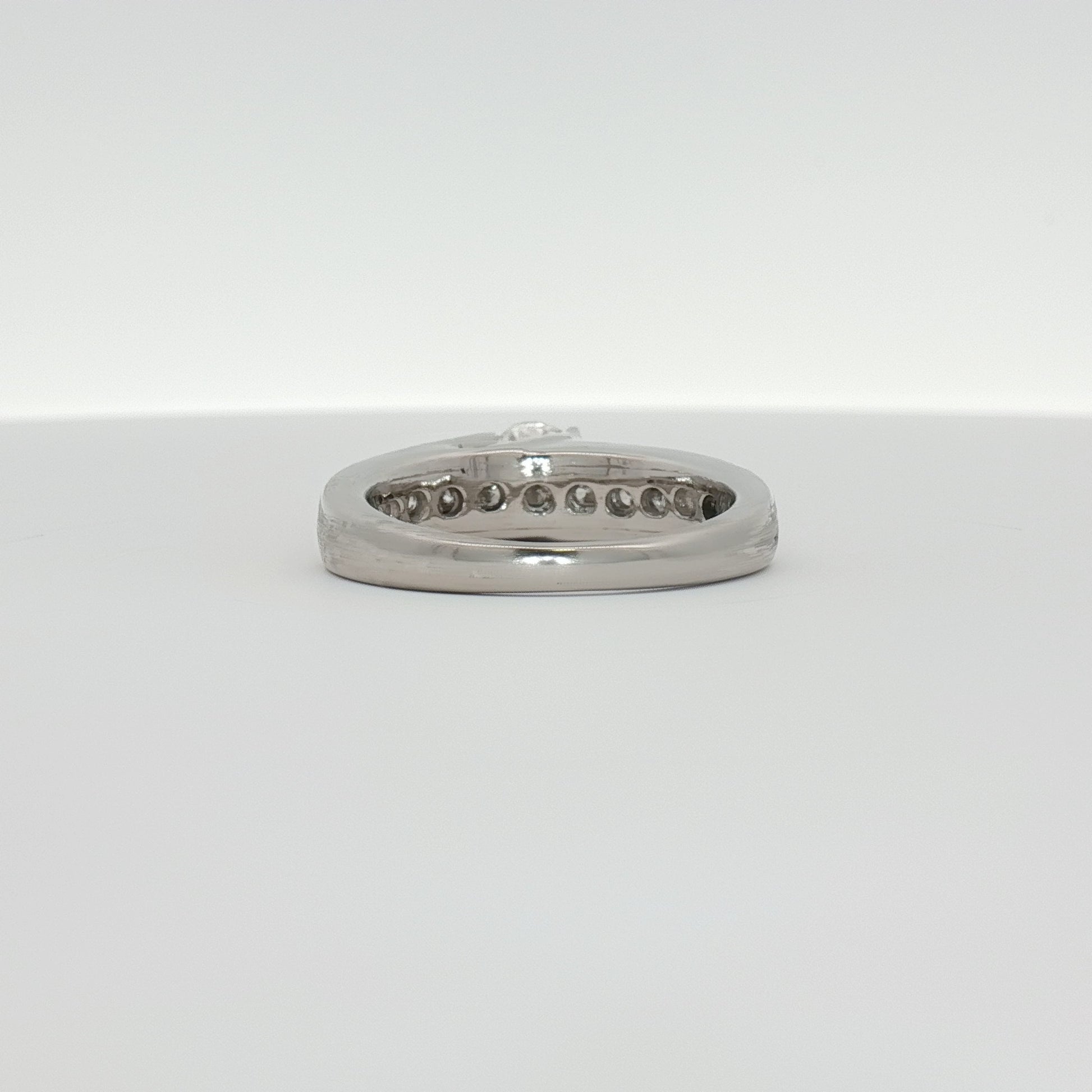 Platinum diamond ring from Gold & Beyond featuring a sparkling central diamond and sleek band design.