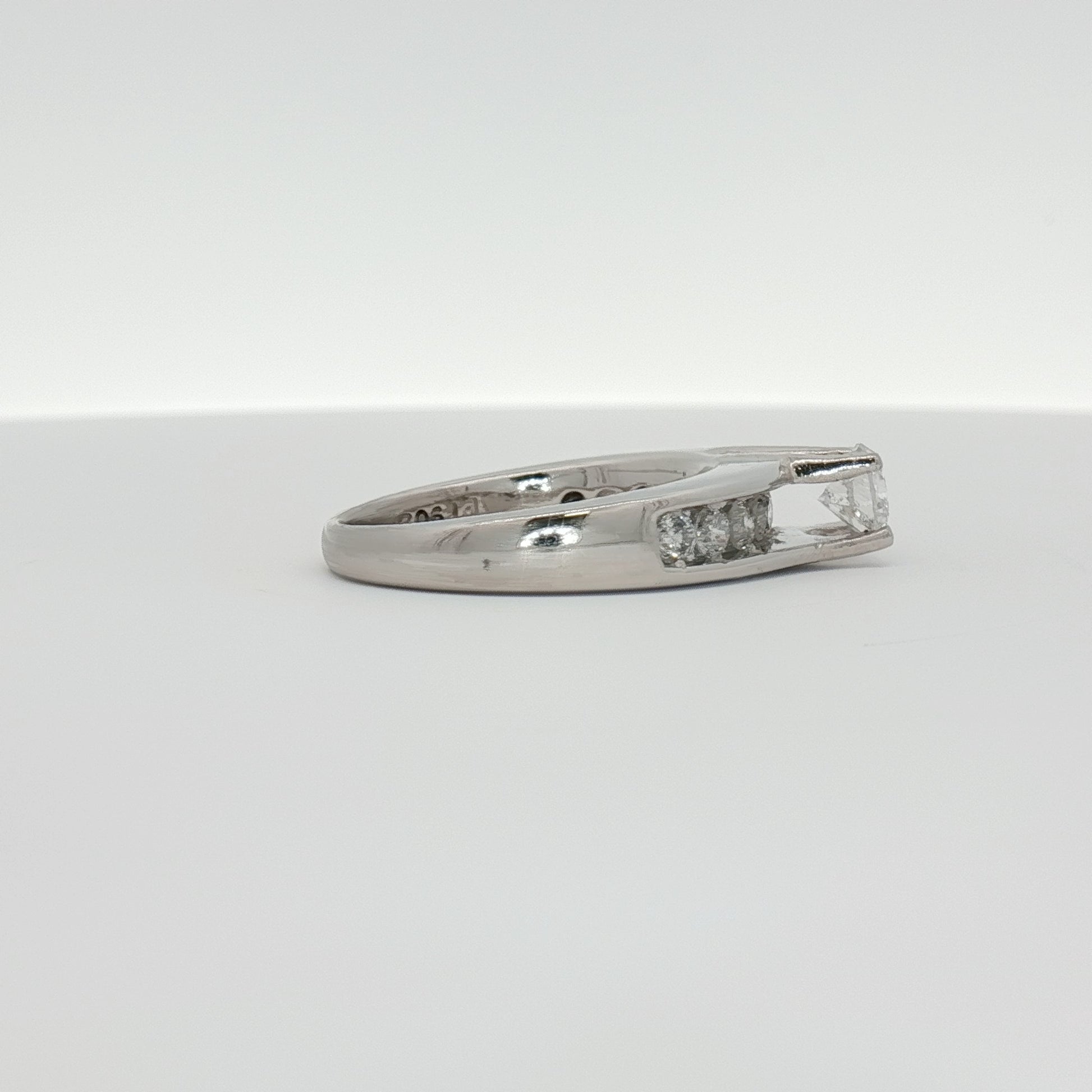 Platinum diamond ring by Gold & Beyond featuring a sparkling central diamond set in elegant jewelry design