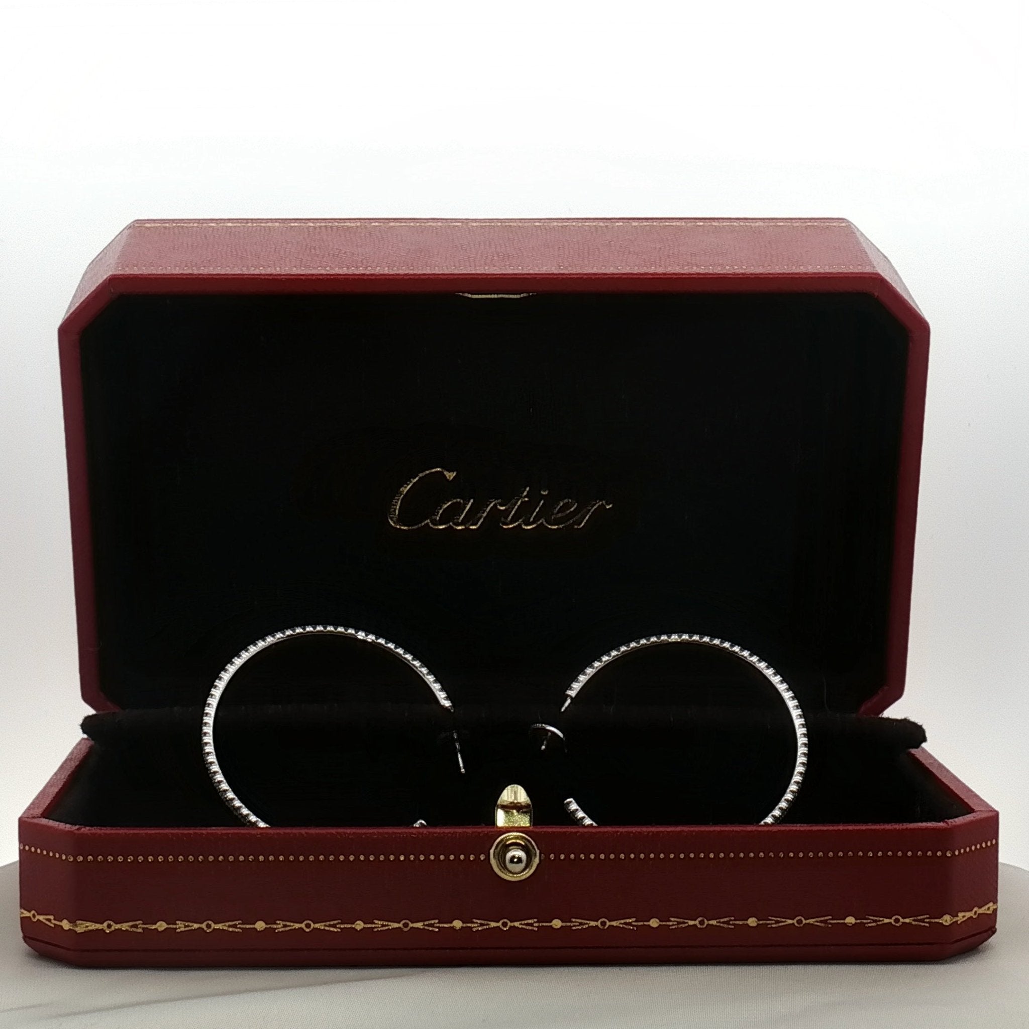 Cartier diamond hoop earrings in gold jewelry with sparkling diamonds and a sleek hoop design.