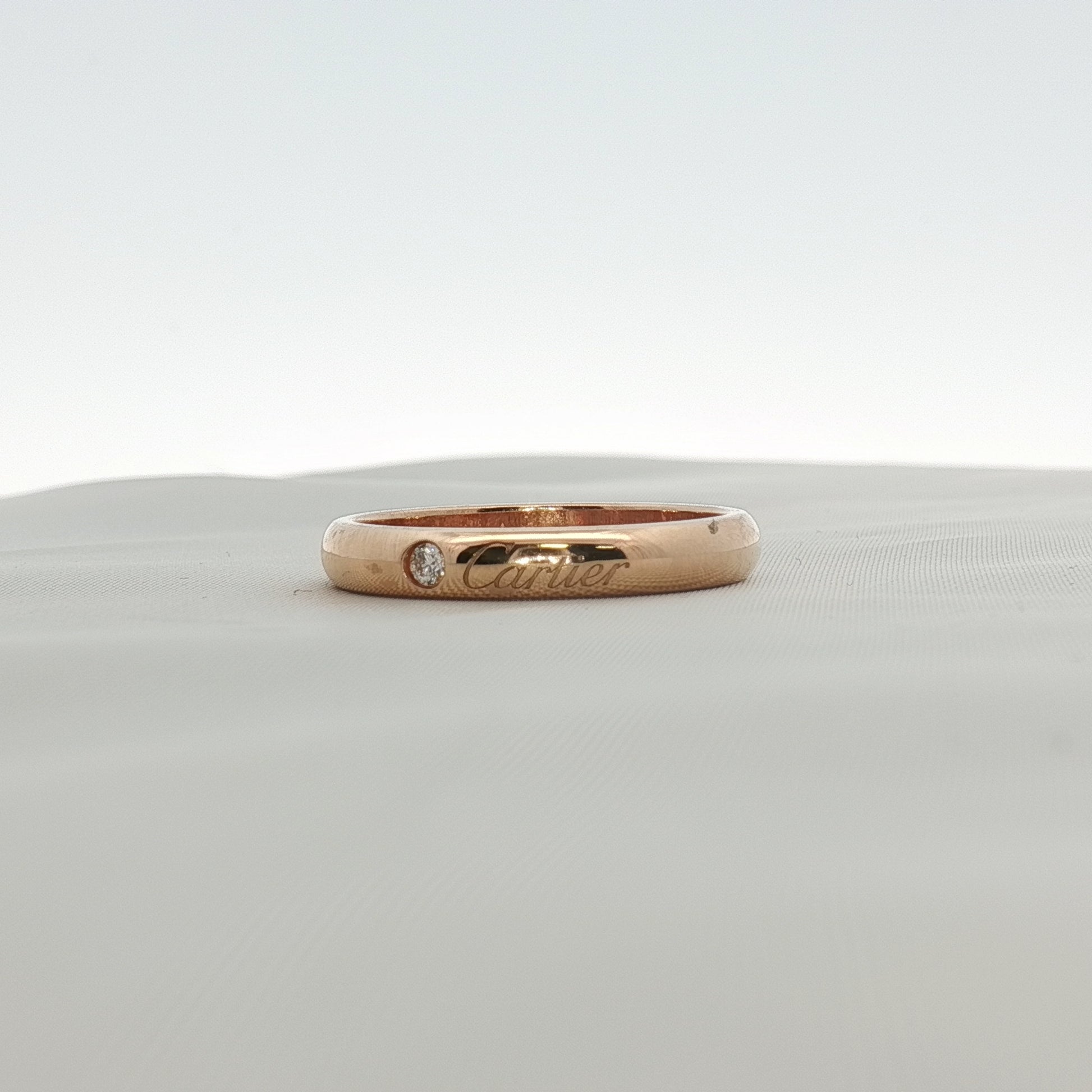 Gold & Beyond Cartier Love wedding band with diamonds, showcasing a sleek gold ring with sparkling diamond accents.