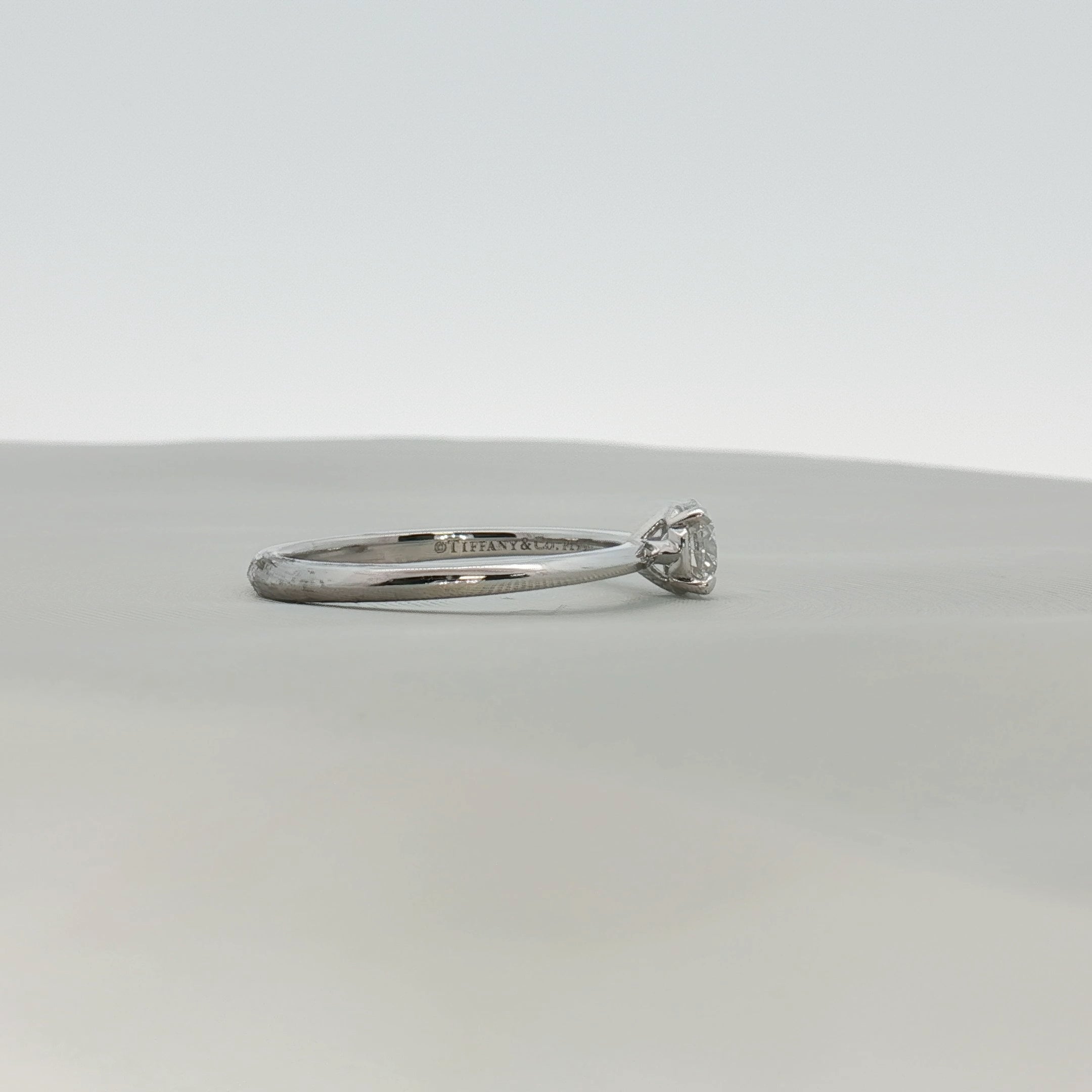 Gold & Beyond Tiffany & Co. True Engagement Ring featuring a sparkling diamond solitaire in a sleek jewelry setting.