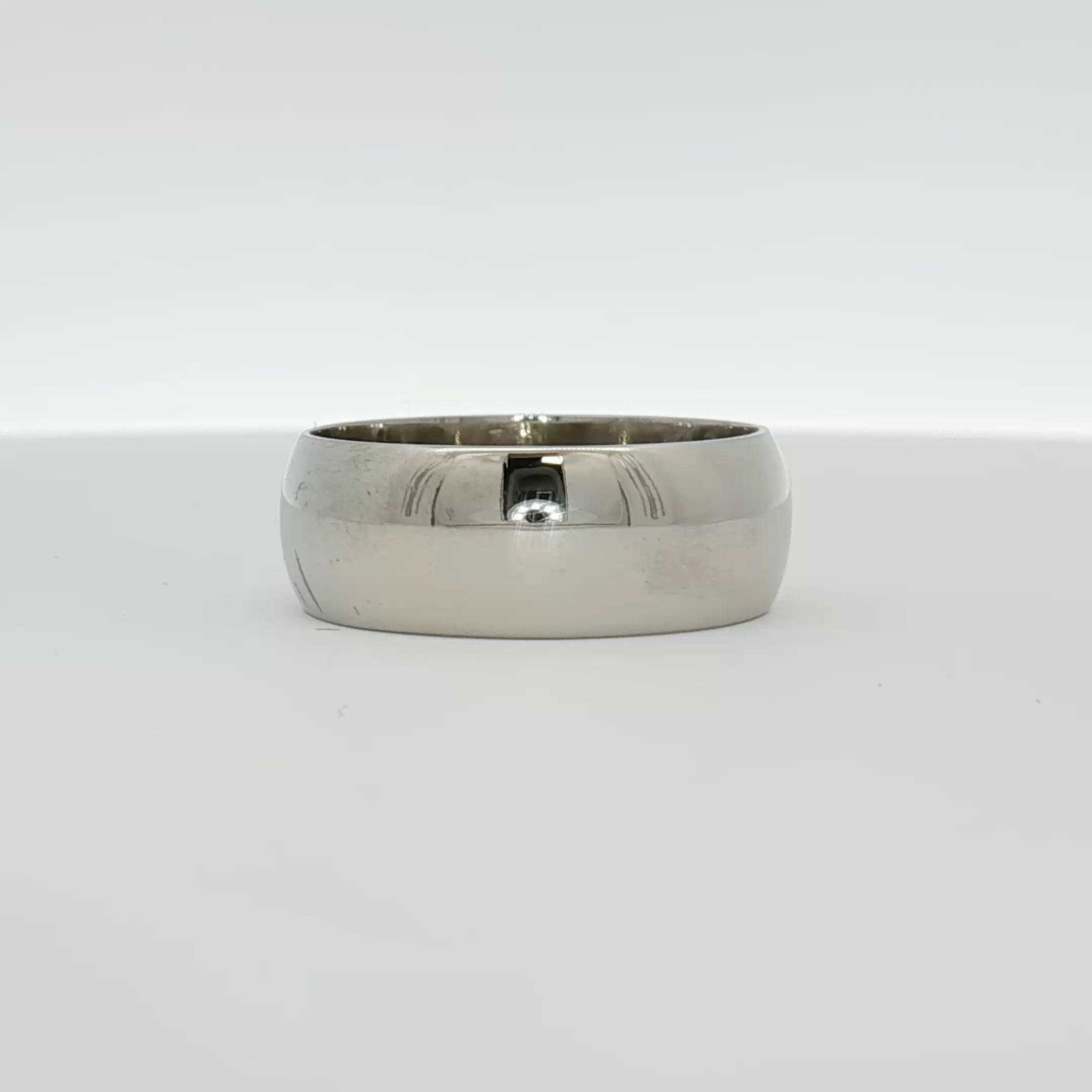 Elegant gold gentleman’s wedding band by Gold & Beyond, showcasing a smooth, polished jewelry design on a neutral background.