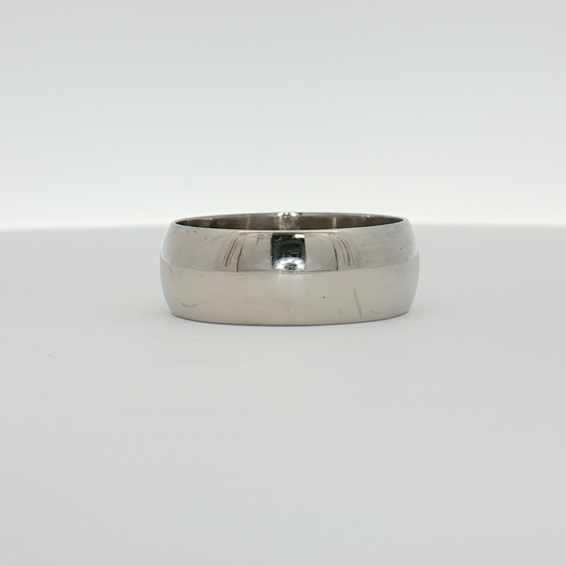 Gold & Beyond gentleman’s wedding band jewelry featuring a sleek, polished gold ring suitable for wedding or special occasions.