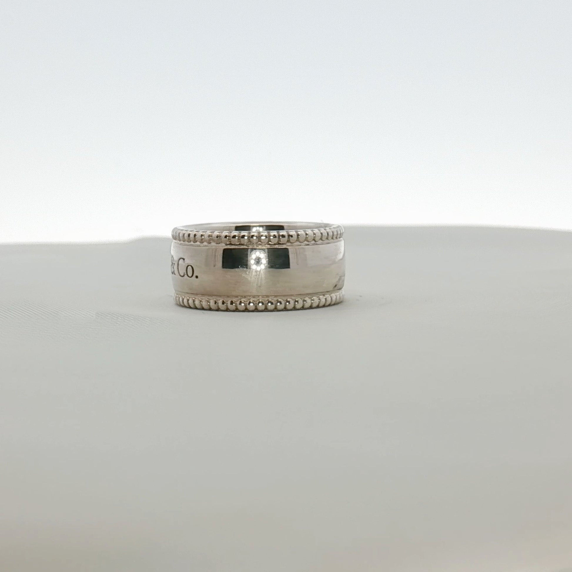 Sterling silver Tiffany & Co. milgrain band jewelry with intricate textured detailing, showcasing craftsmanship and elegant design.
