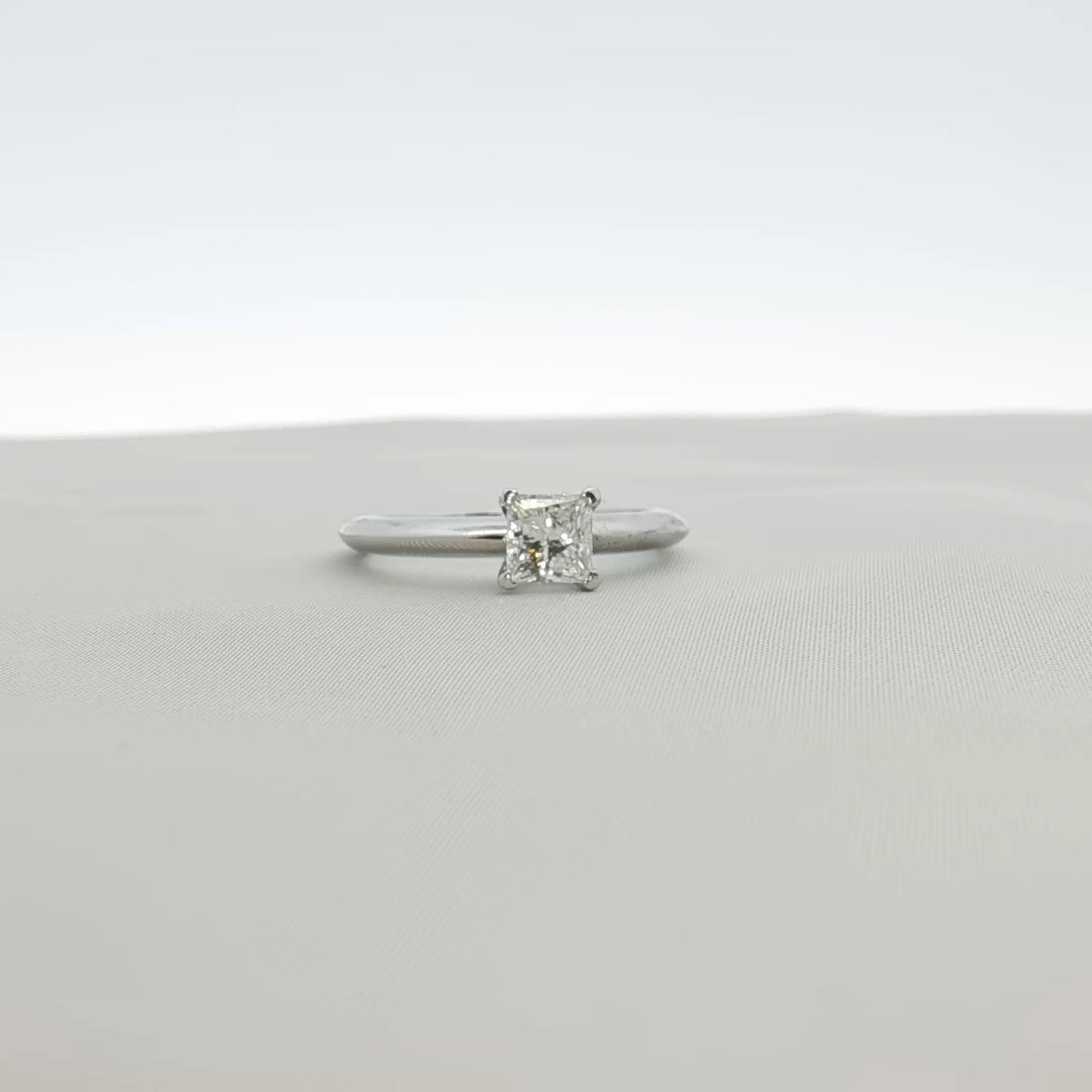 Gold & Beyond Tiffany & Co. princess-cut diamond solitaire ring with a sleek platinum band, showcasing a sparkling center stone.