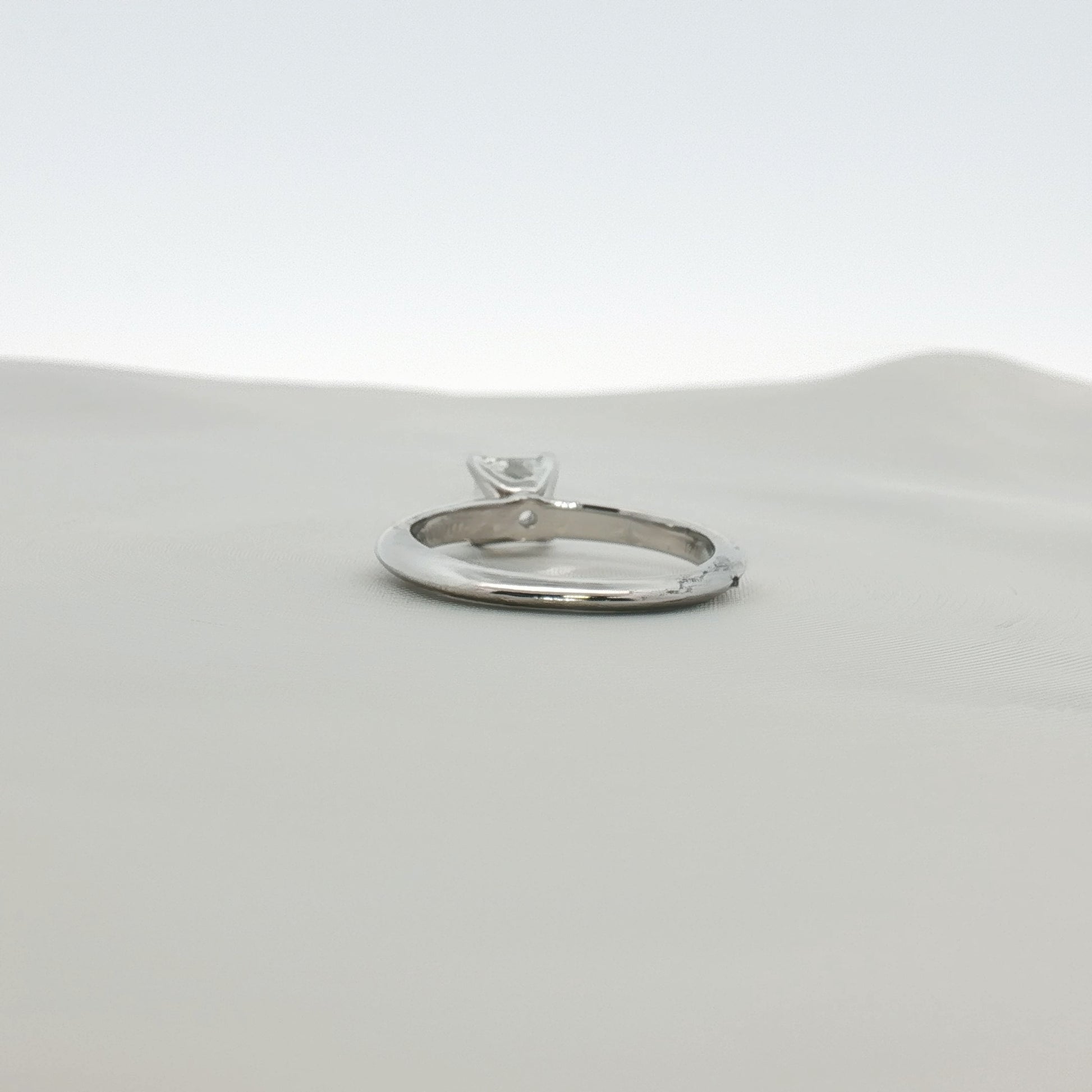 Tiffany & Co. Princess-Cut Diamond Solitaire Ring with a gold band, showcasing a sparkling central diamond.
