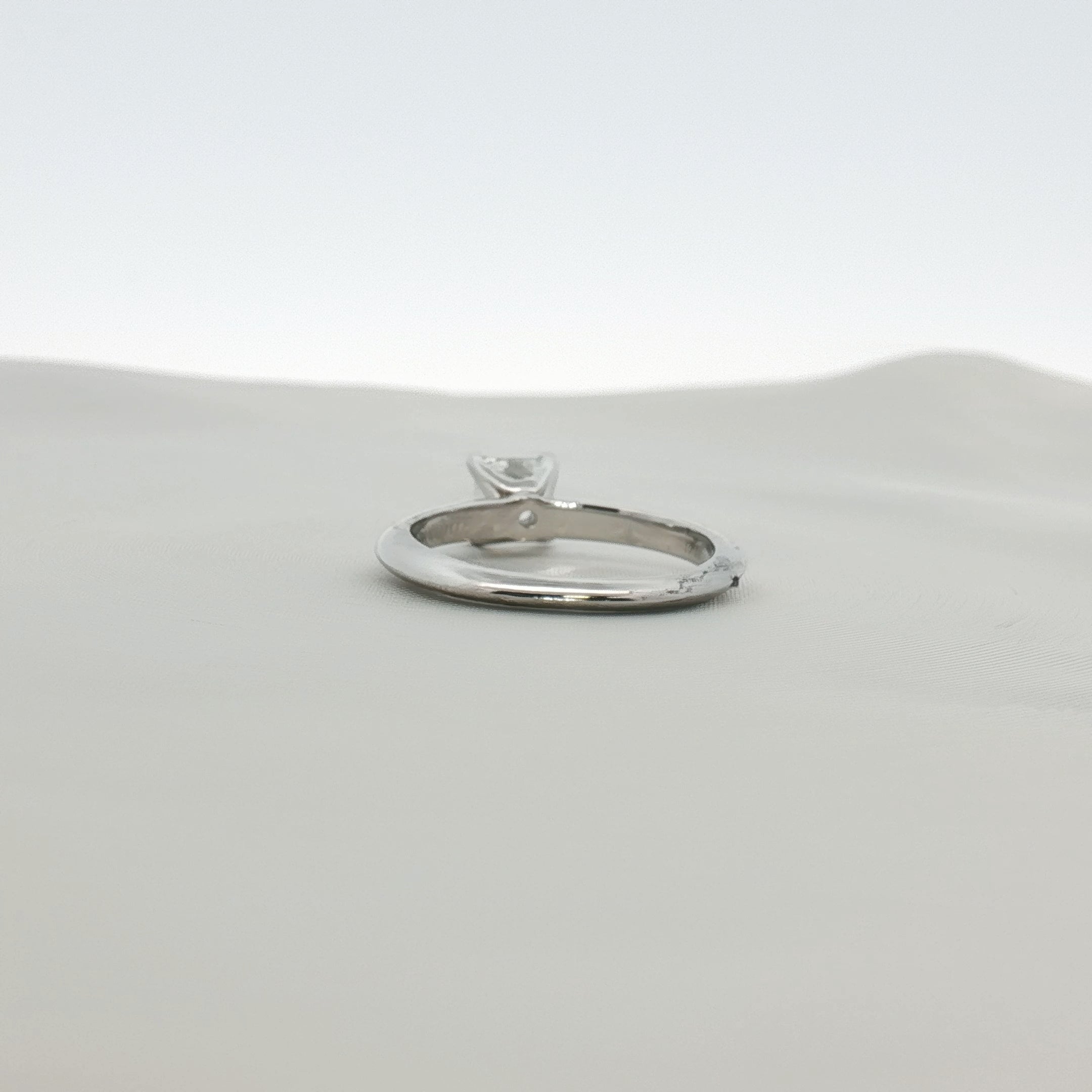 Tiffany & Co. Princess-Cut Diamond Solitaire Ring with a gold band, showcasing a sparkling central diamond.