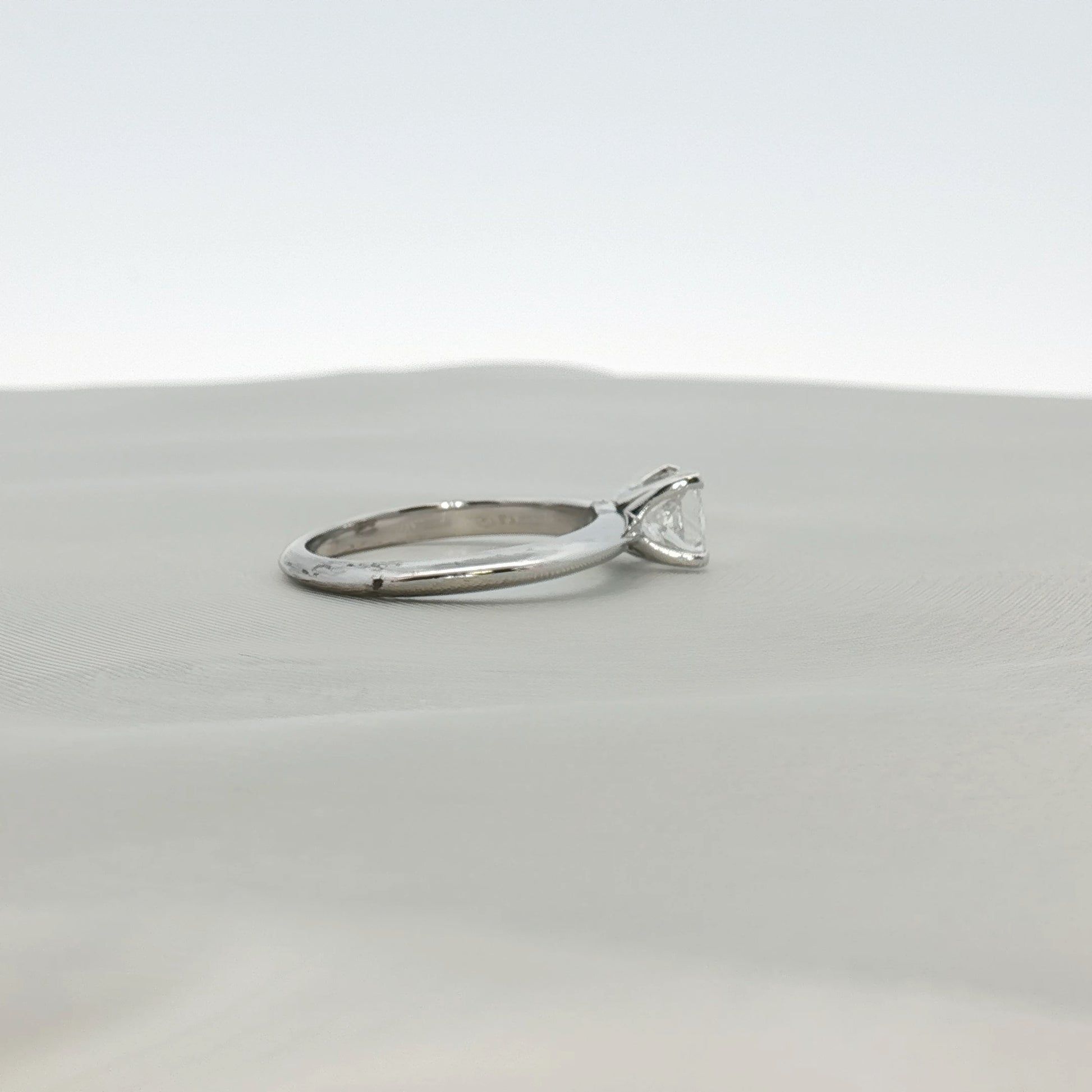Gold & Beyond Tiffany & Co. princess-cut diamond solitaire ring with a sleek band and sparkling center stone.