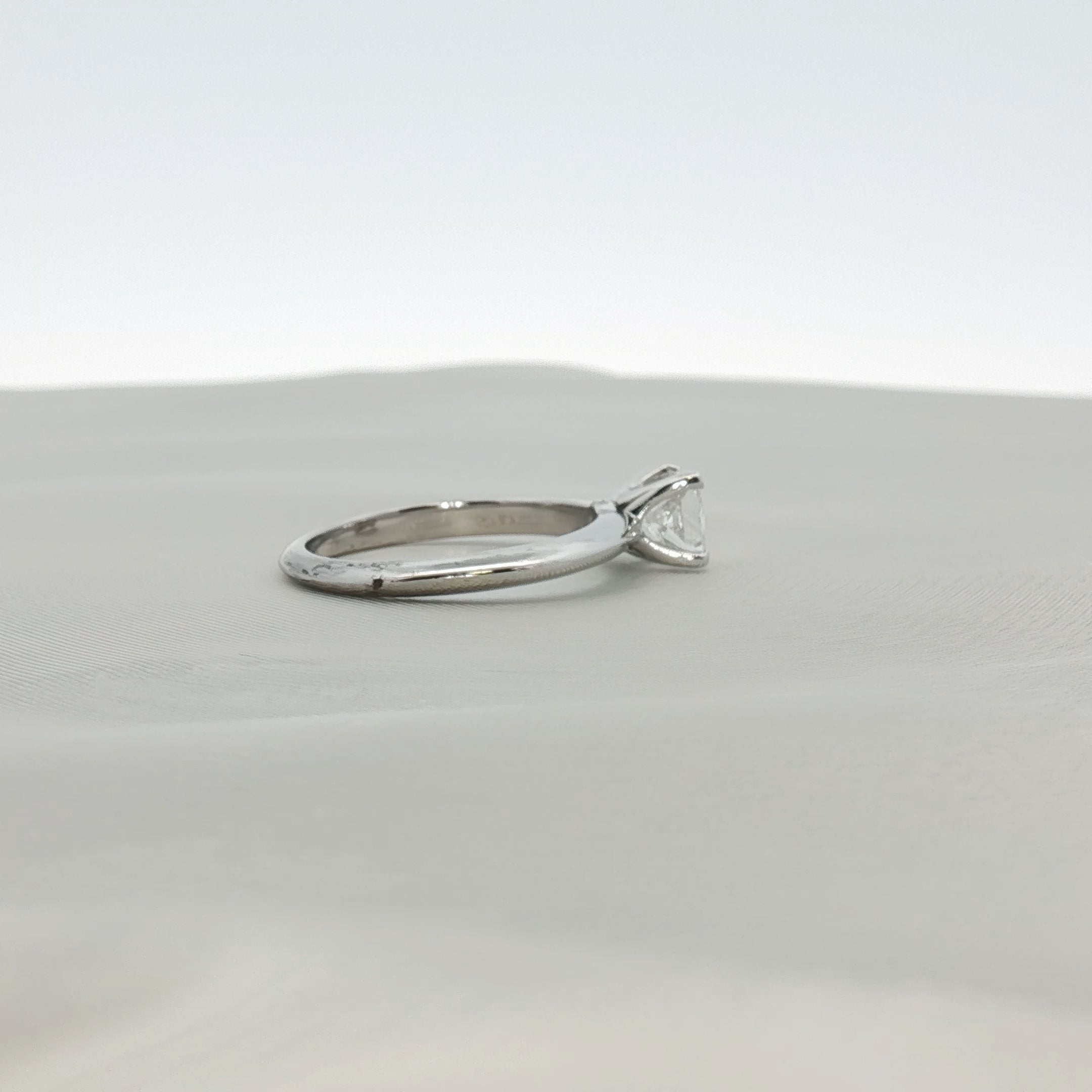 Gold & Beyond Tiffany & Co. princess-cut diamond solitaire ring with a sleek band and sparkling center stone.